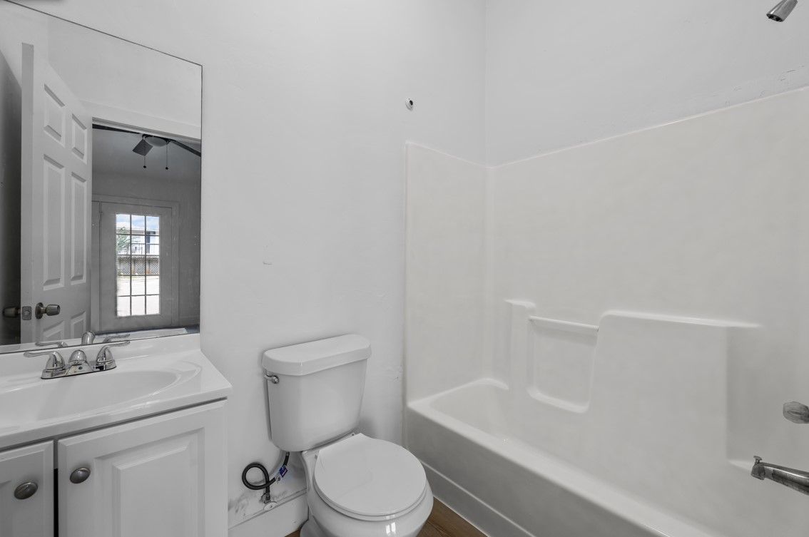 A bathroom with a toilet , sink , and bathtub.
