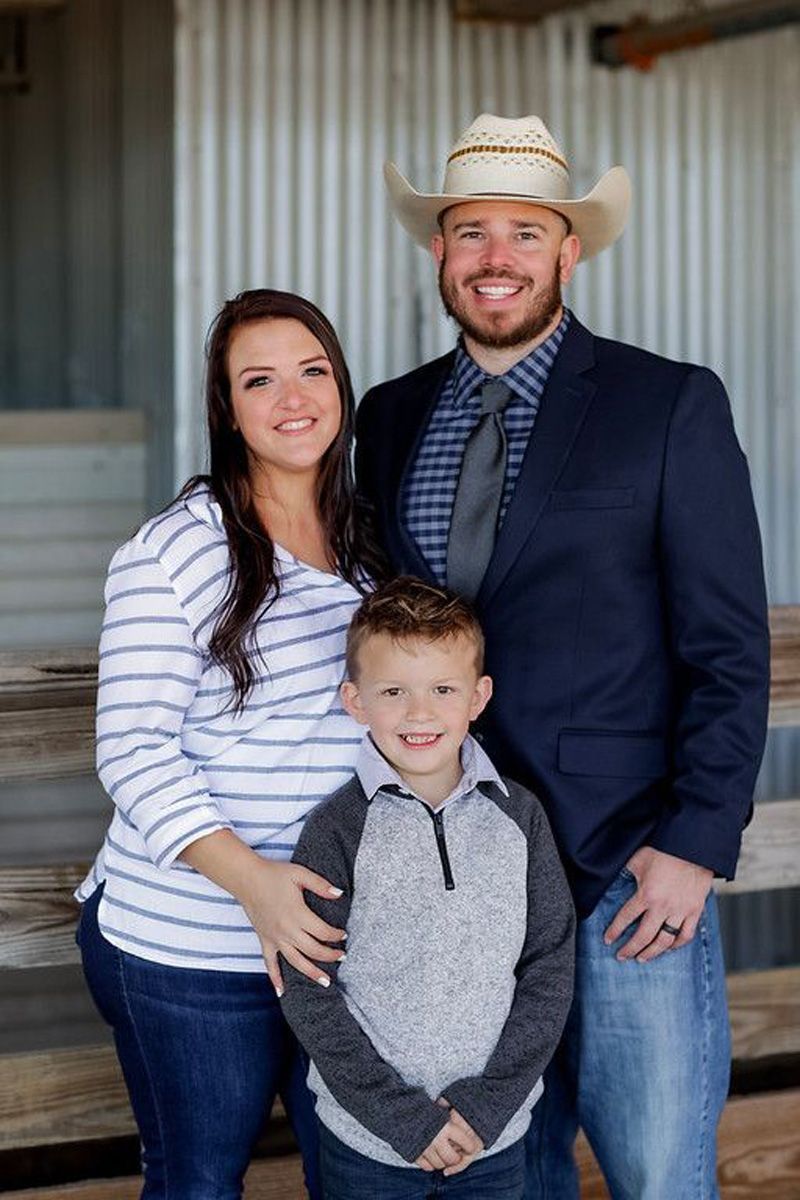 A man in a cowboy hat is standing next to a woman and a boy.