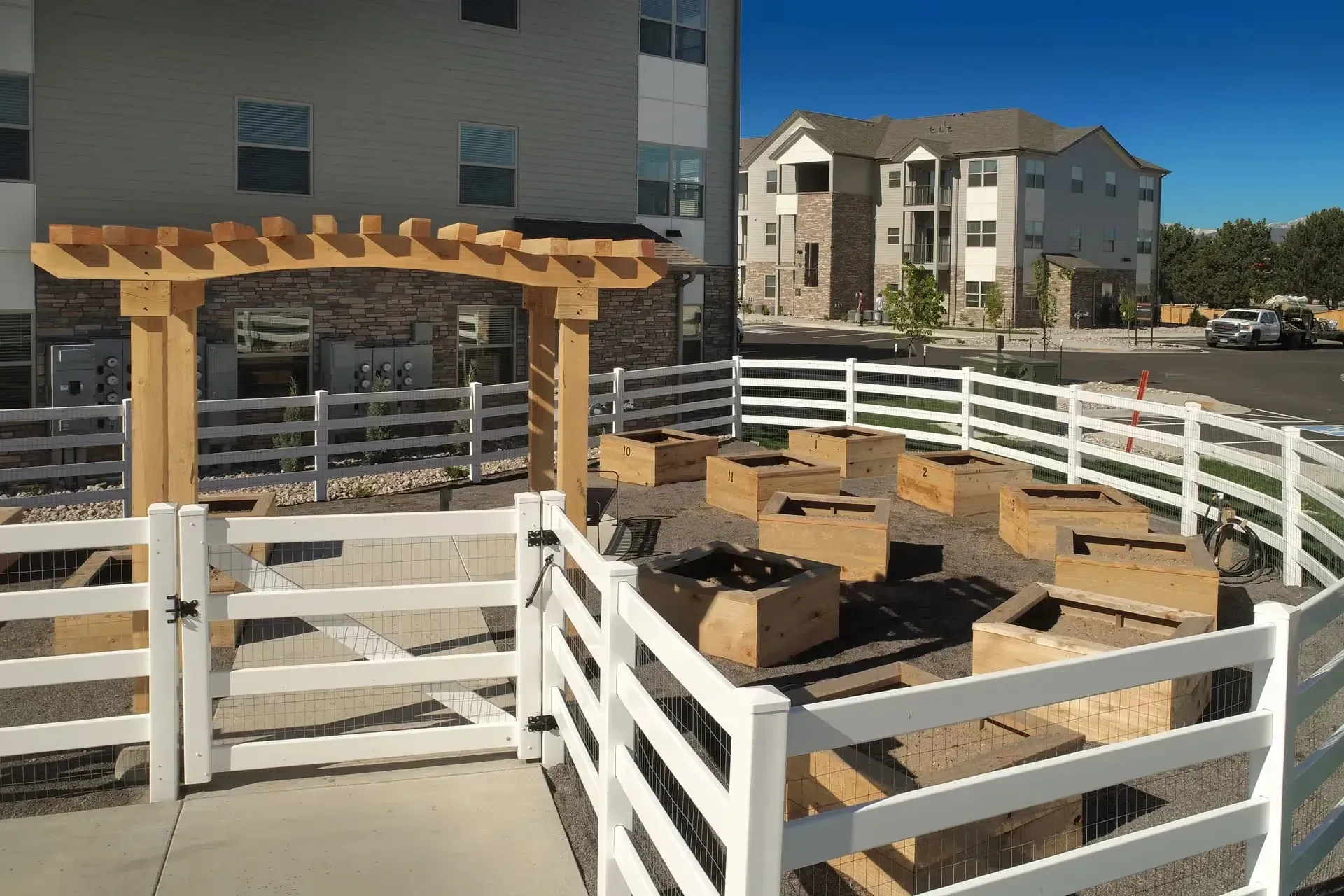 Community garden with raised beds and a wooden pergola.