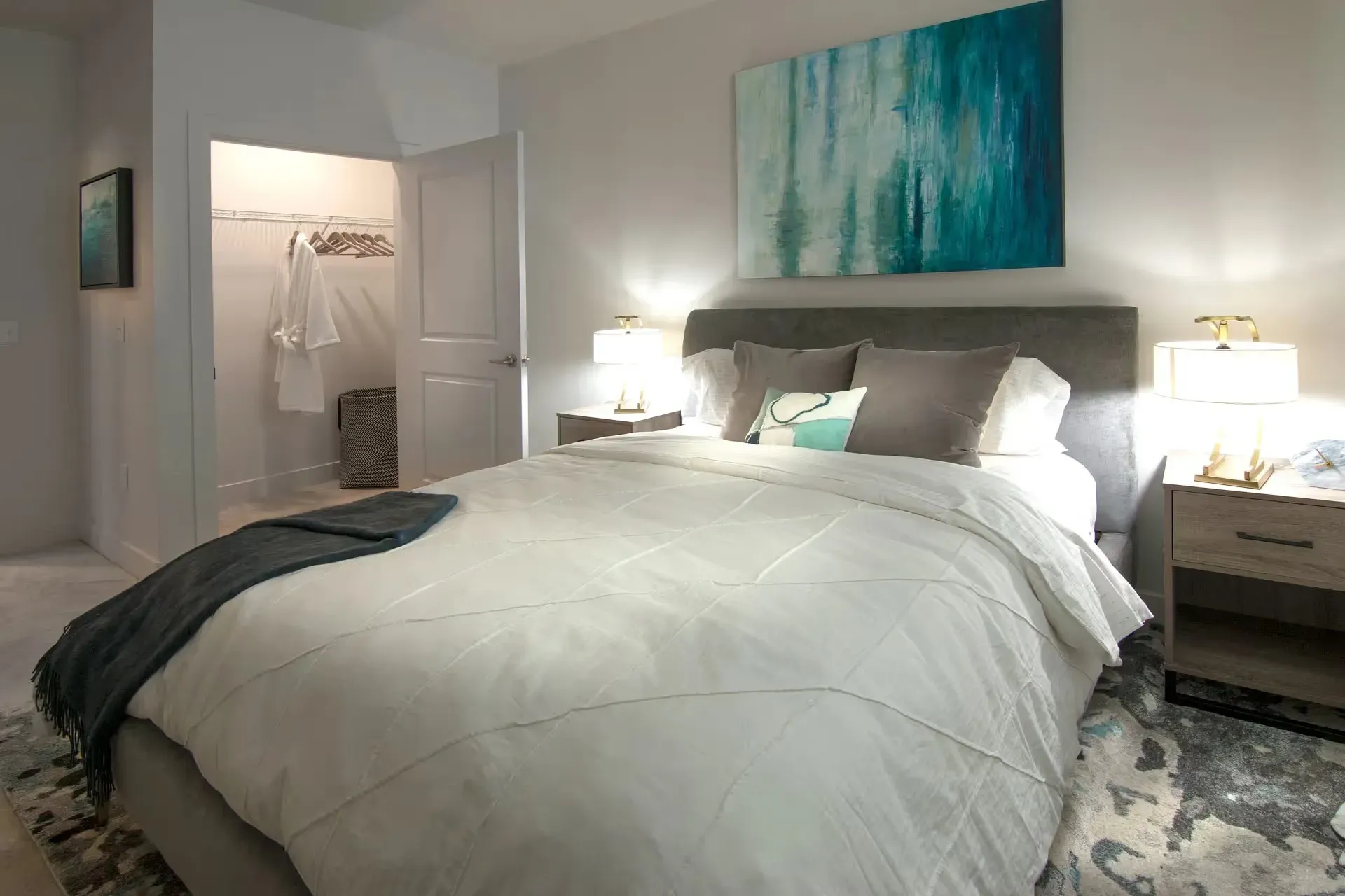 A beautifully staged bedroom with a queen-sized bed, nightstands, and a walk-in closet.
