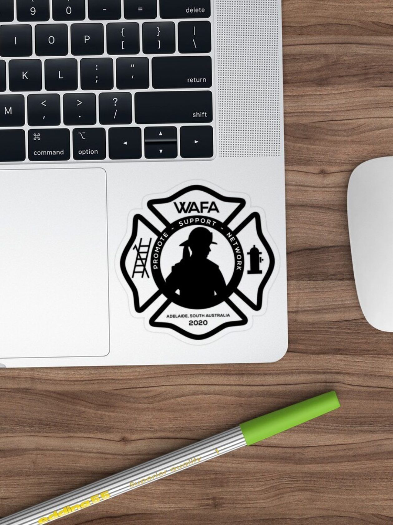 A black firefighter emblem sticker on a laptop. Includes a silhouette, ladder, and hydrant.
