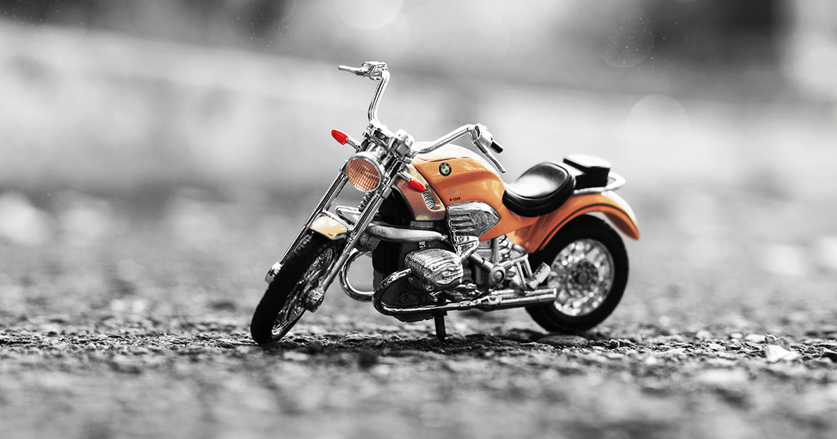 black and white image with orange motorcycle