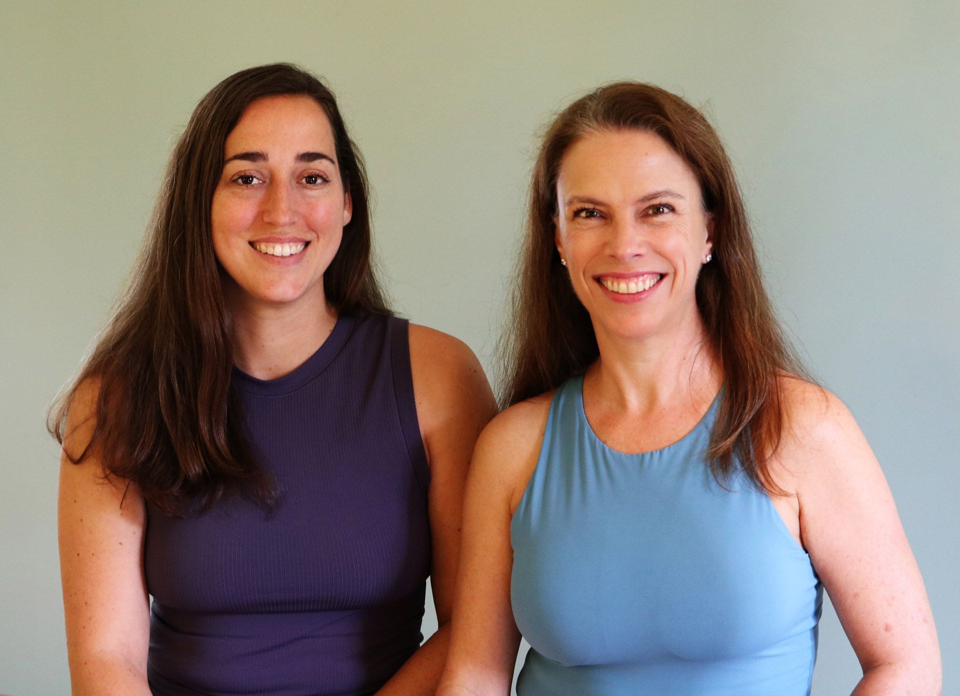 two women are standing next to each other and smiling for the camera .