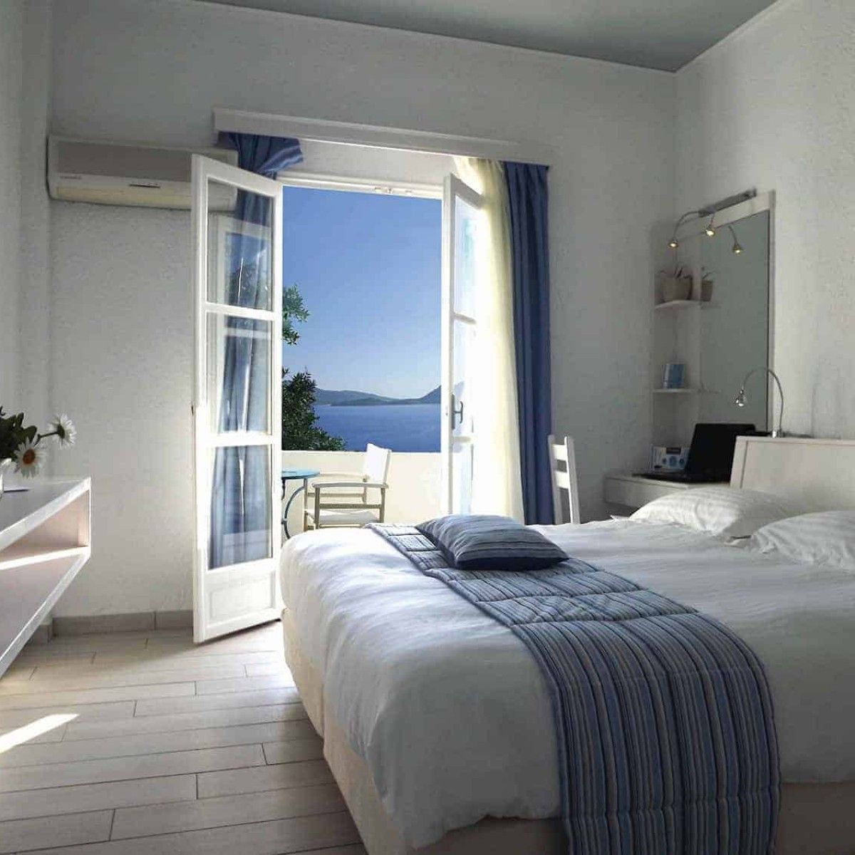 a hotel room in Greece with a bed and a view of the ocean