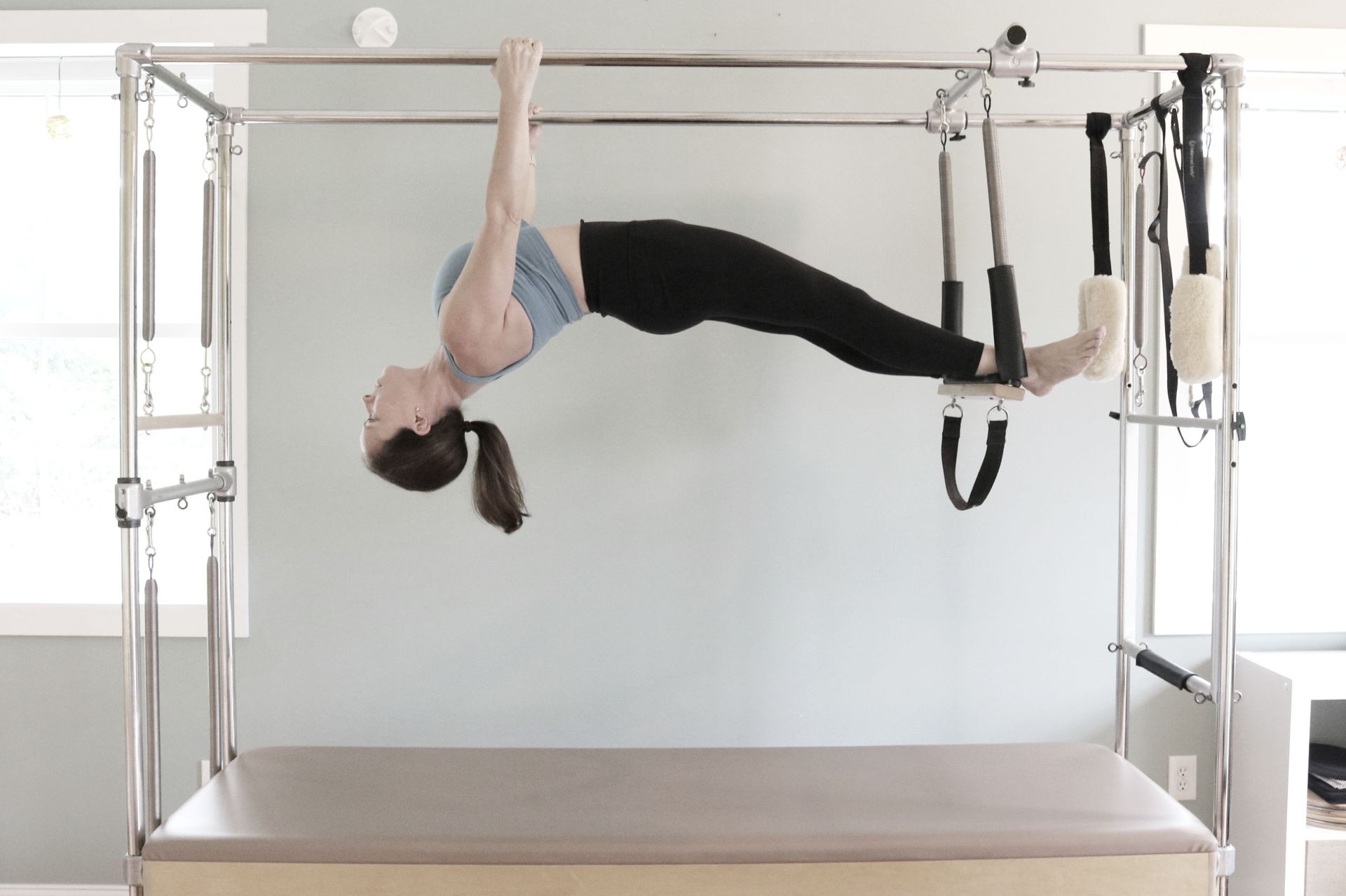 a woman is doing a handstand on a pilates machine .