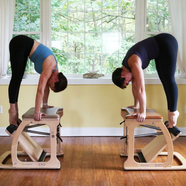 two women are doing stretching exercises on pilates equipment