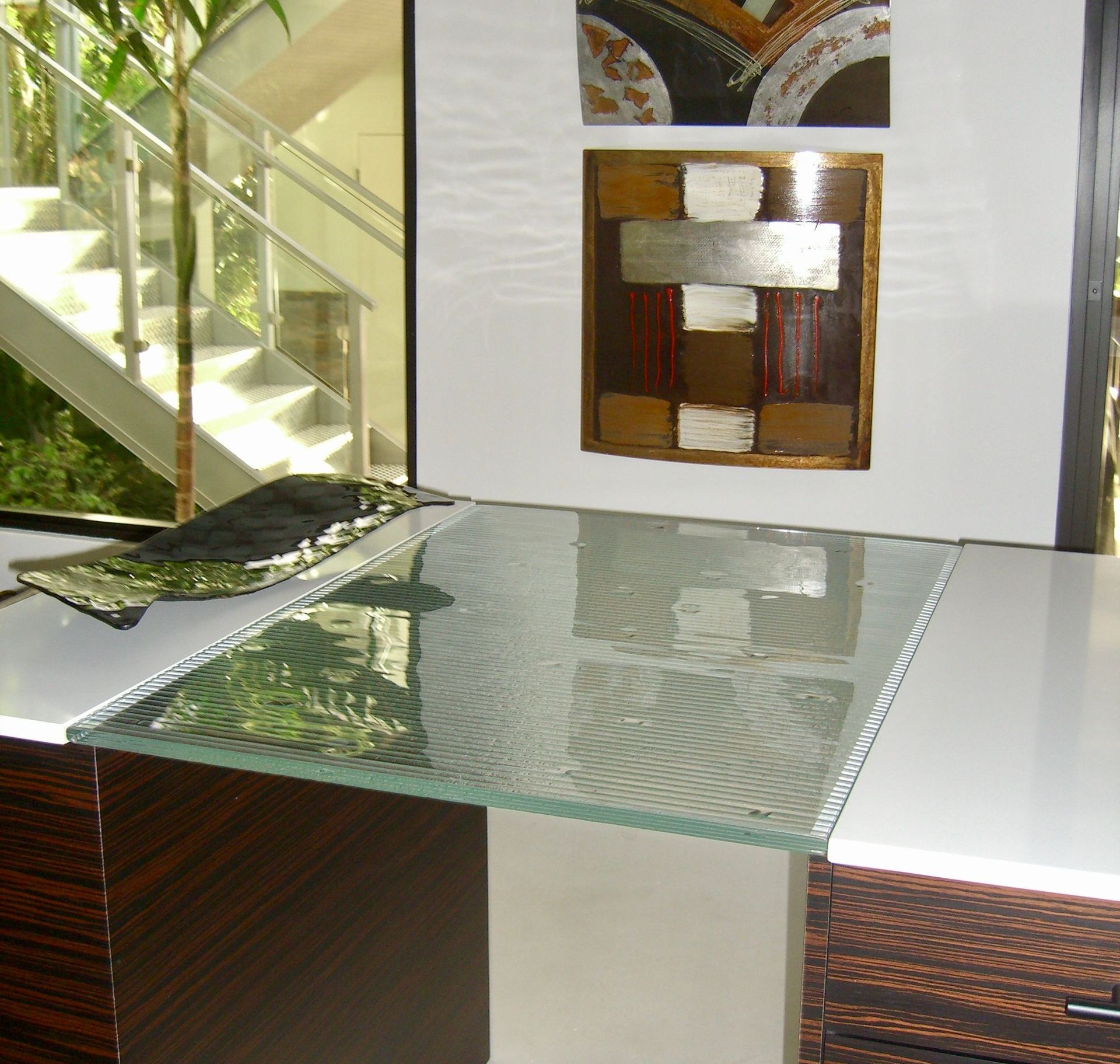 A table with a glass top in front of a staircase