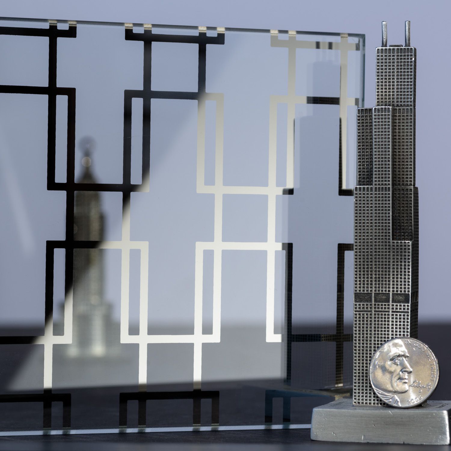 Metal Chicago skyline model, art-deco patterned glass, and coin.