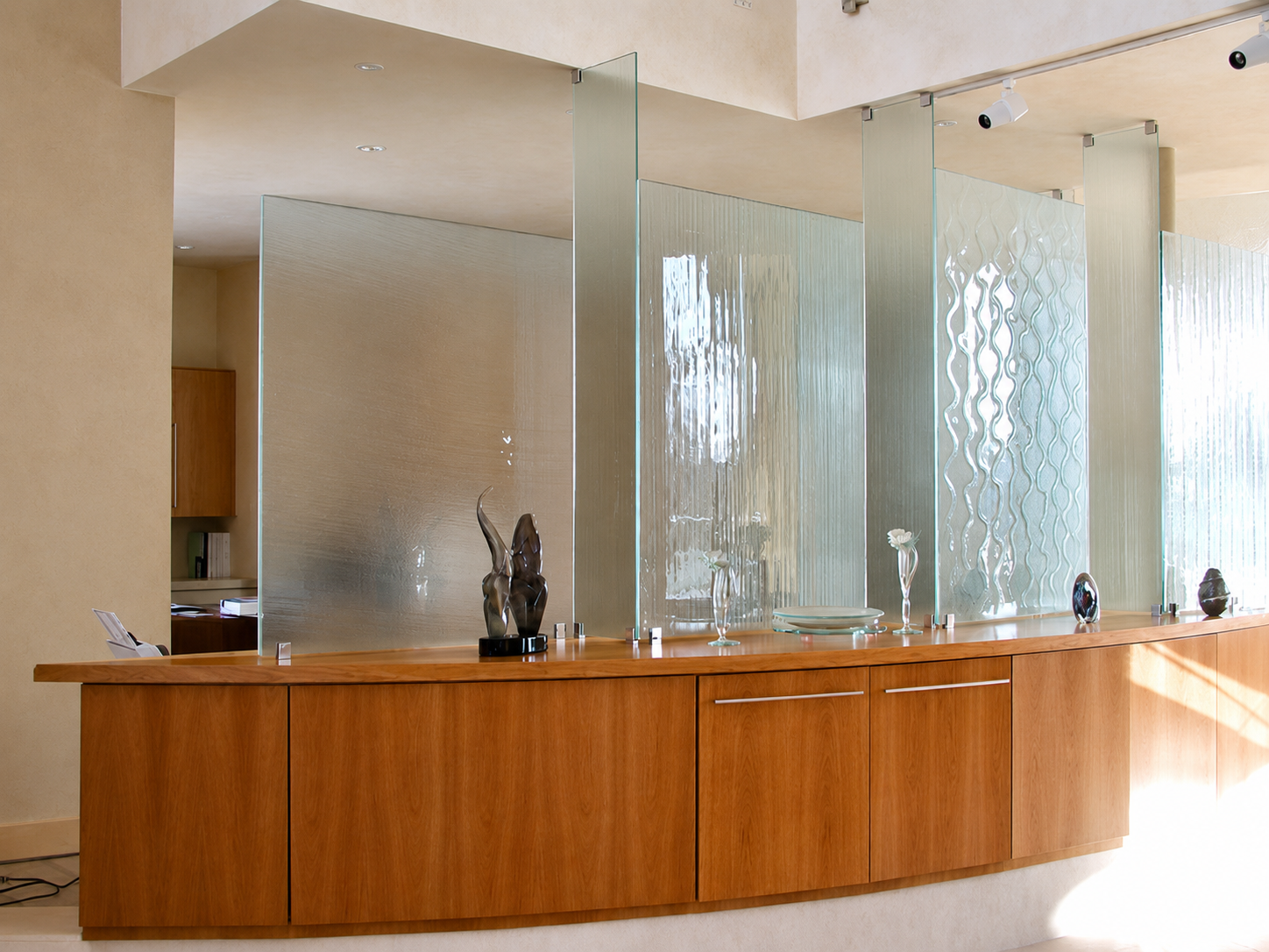 Modern hotel reception desk with wood paneling and frosted glass partitions