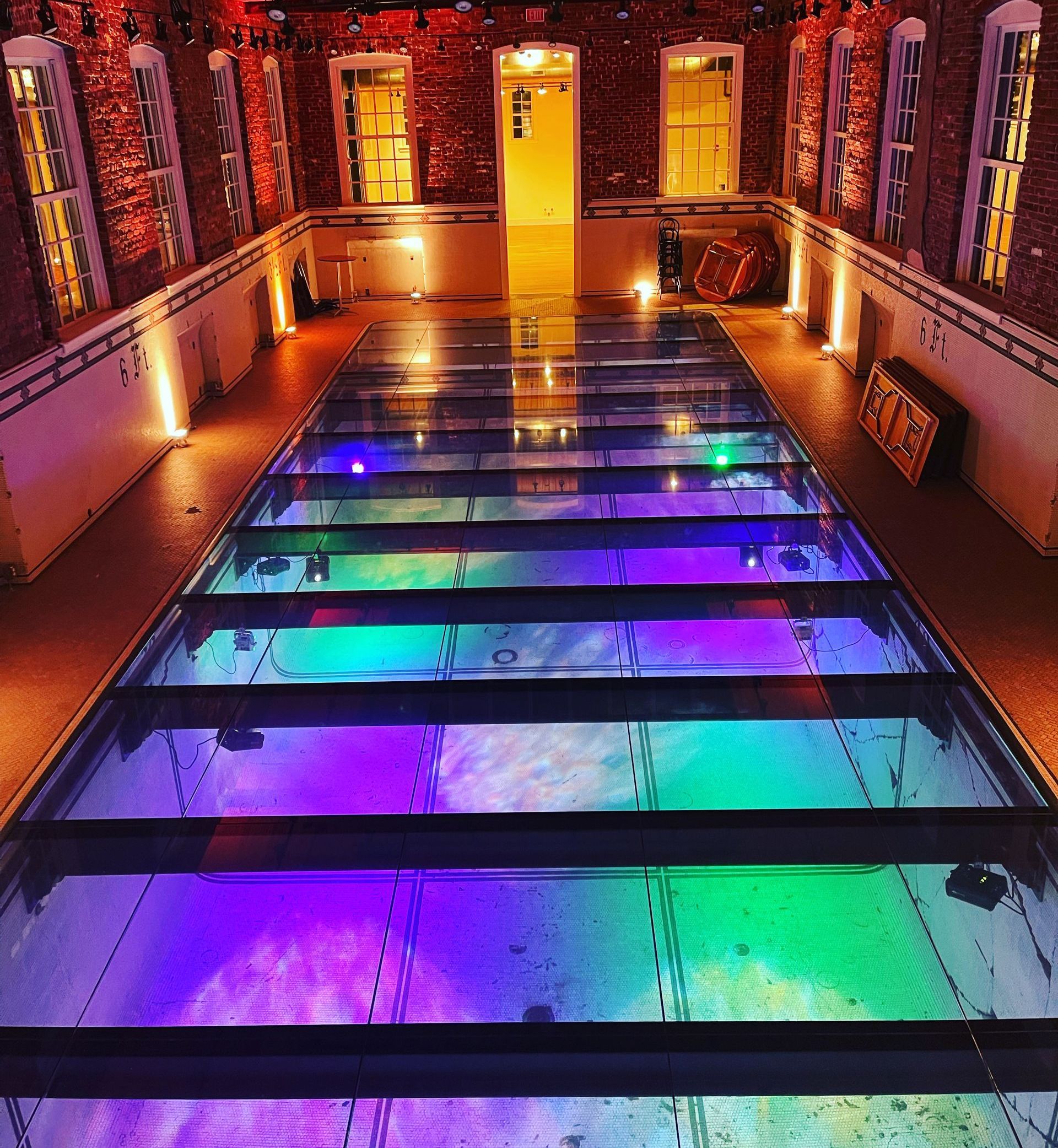 A glass floor with a rainbow of lights under it