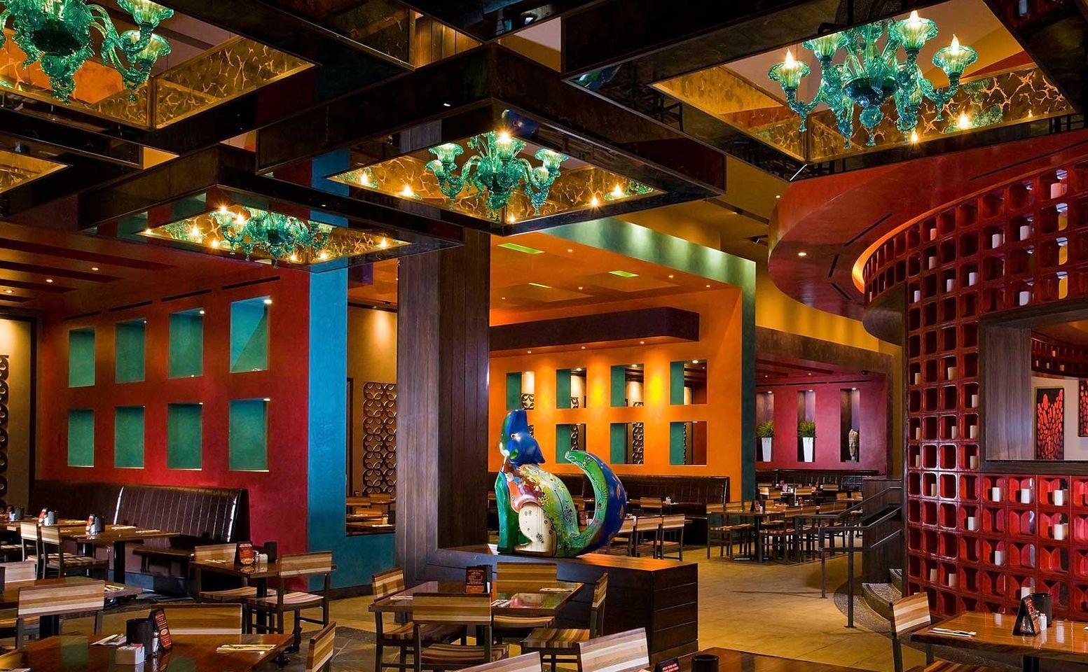 A restaurant with a lot of tables and chairs featuring antique mirrors