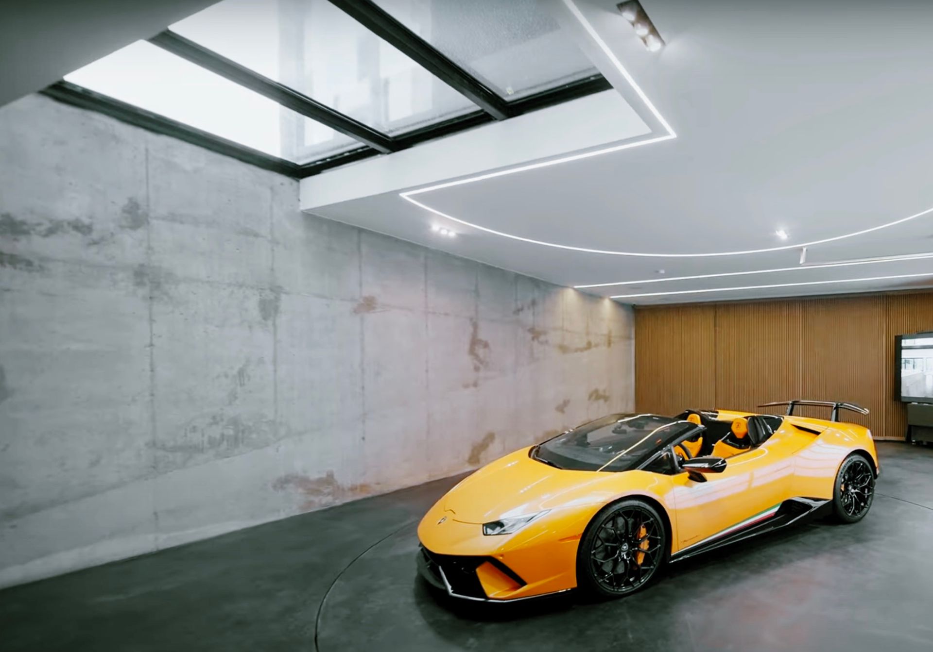 A yellow sports car is parked in a garage.