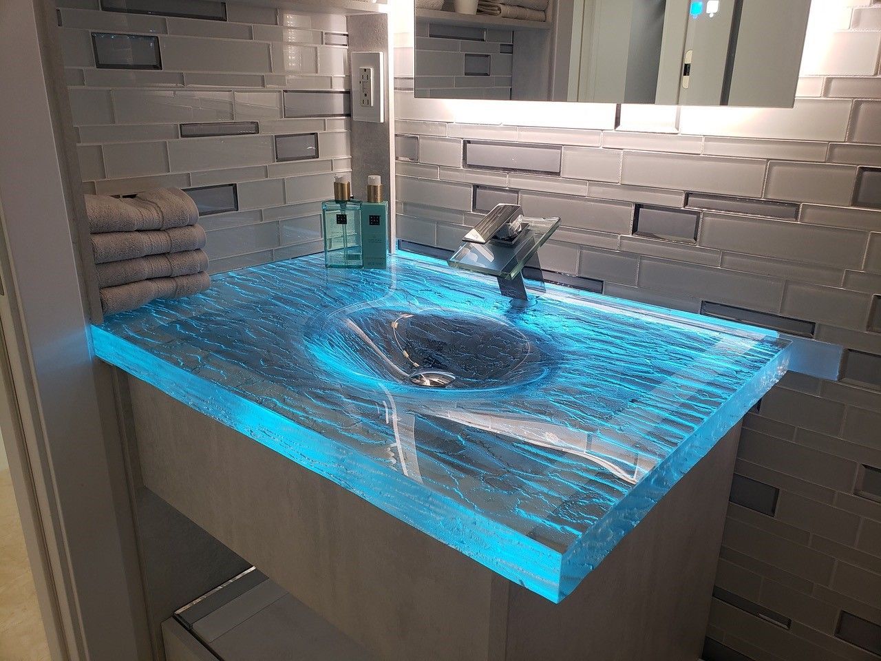 A custom glass countertop vanity in blue thick, textured glass in a residential bathroom.