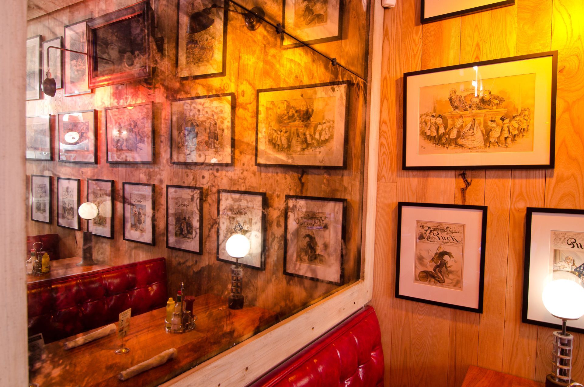 A restaurant with a lot of pictures on the wall and an walled antique mirror