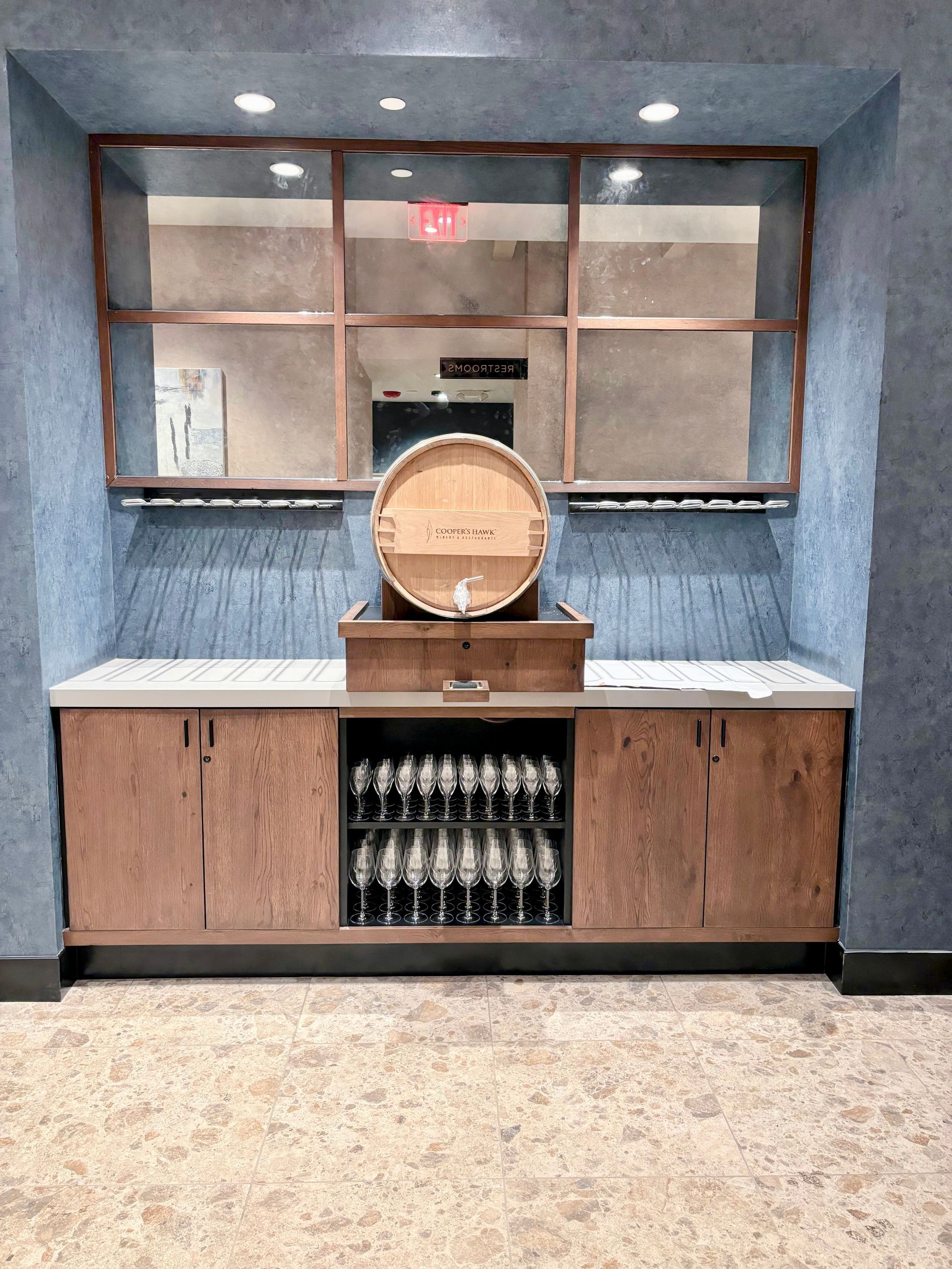 Built-in bar with wooden cabinetry, a barrel, antique mirrors, and wine storage.