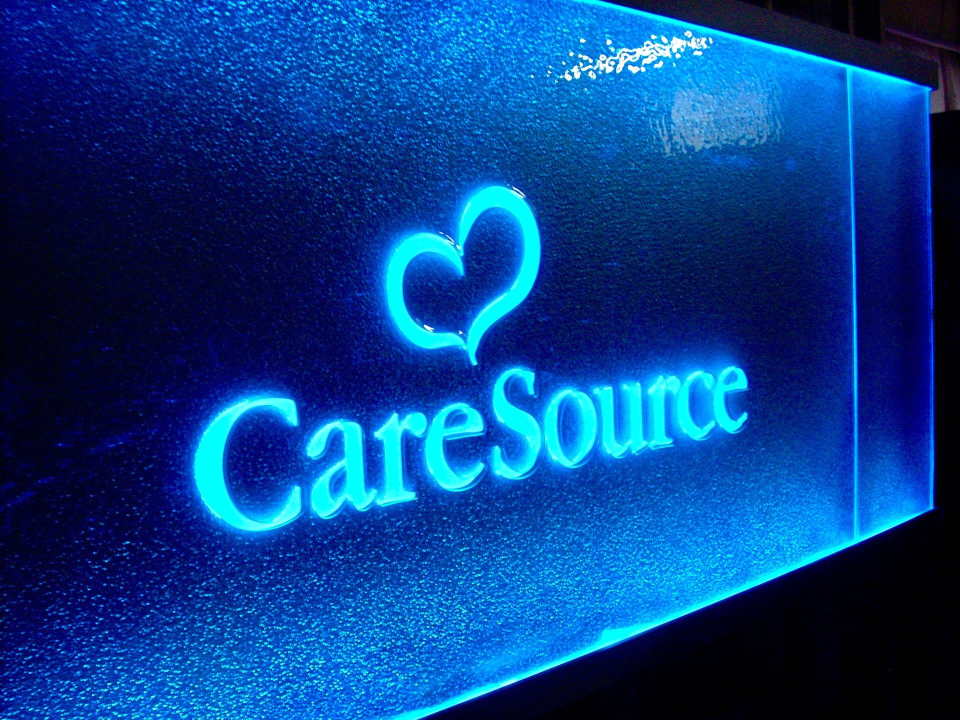 A blue cast glass sign that says caresource on it