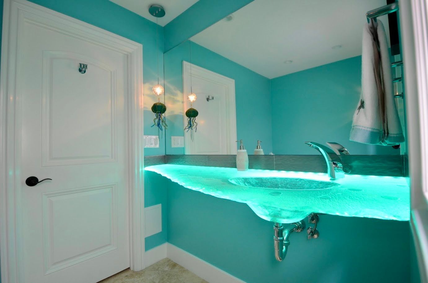 A bathroom with blue glass counter top