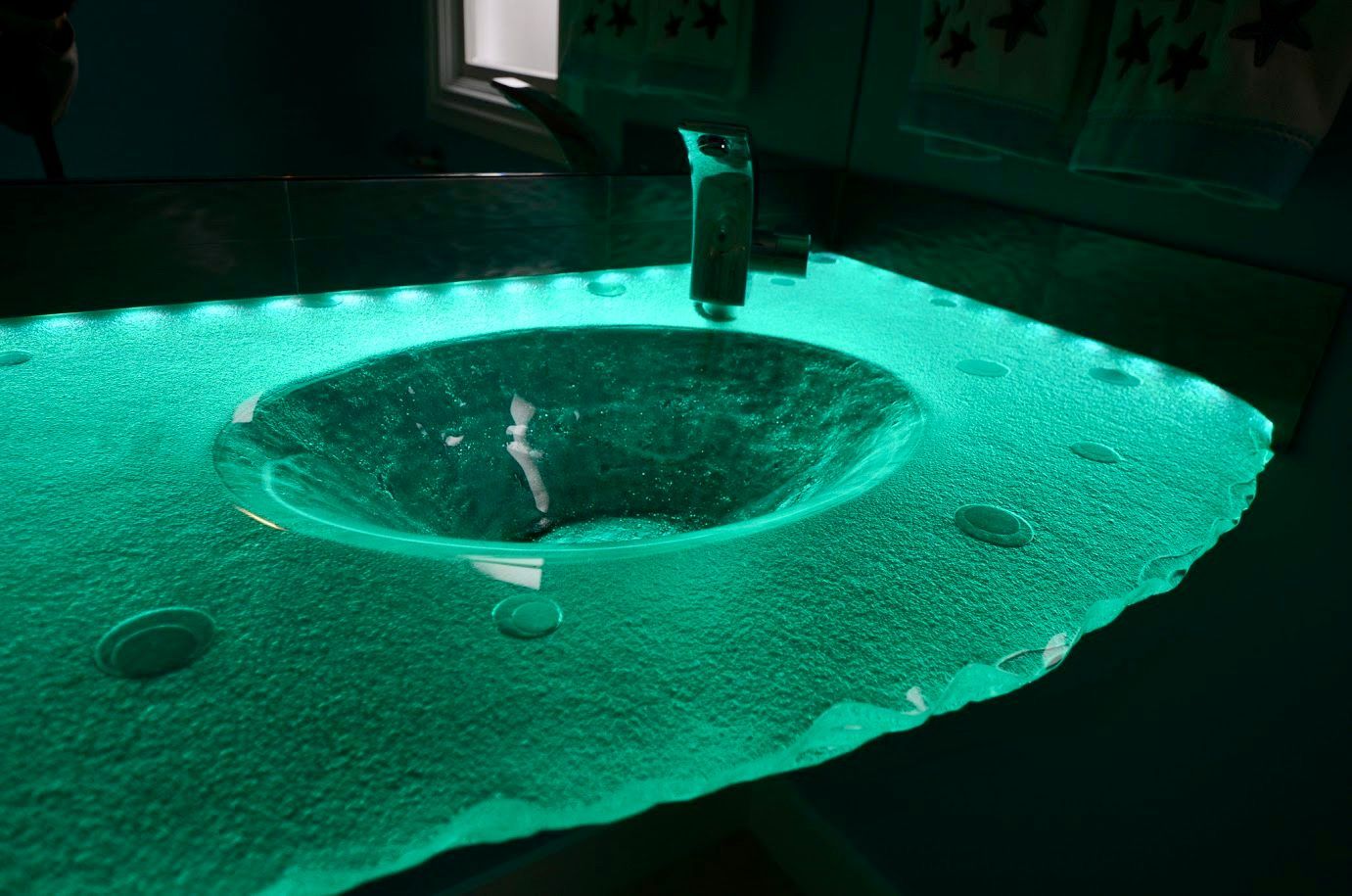 A bathroom glass counter top with integral bowl