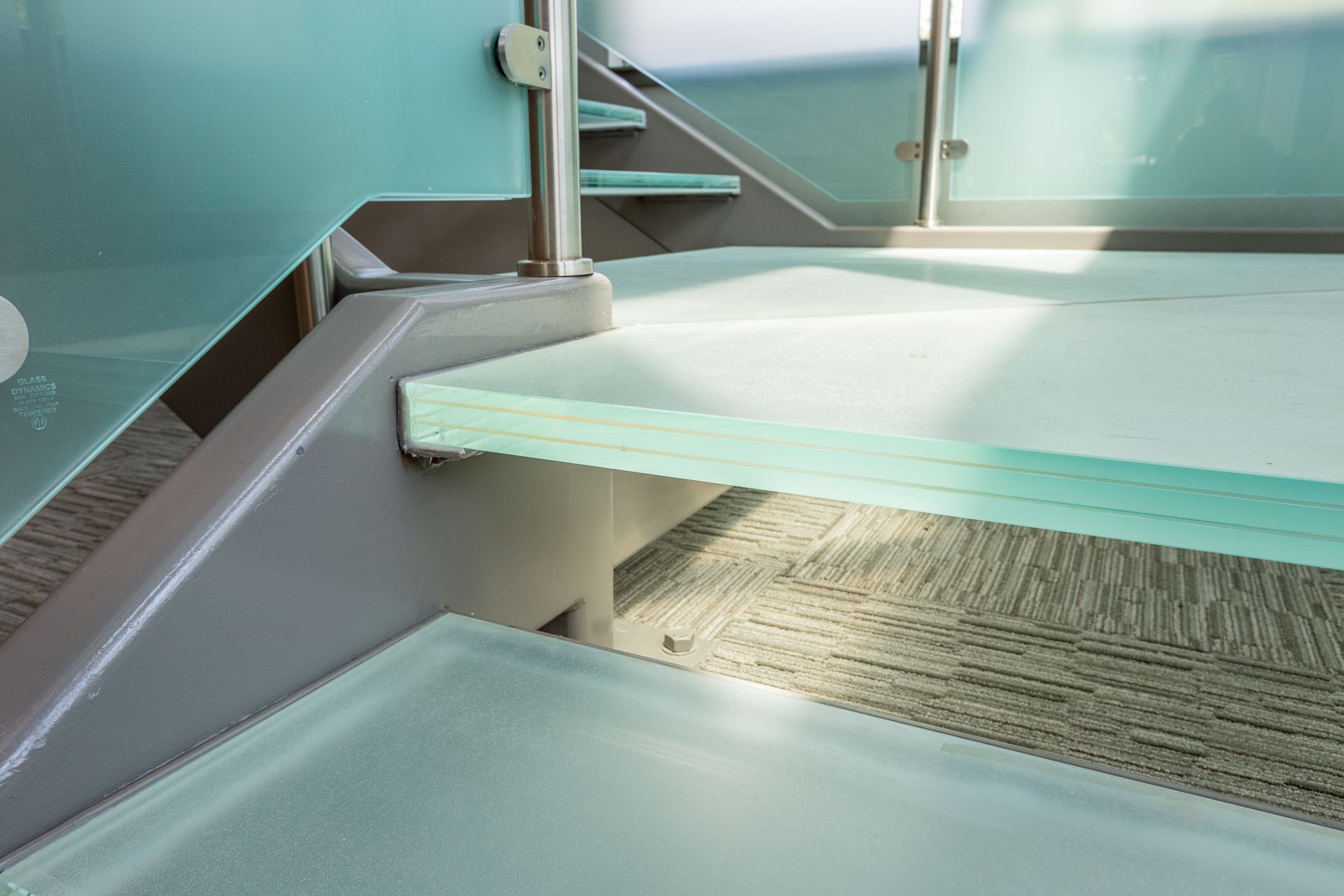 Glass stairs with metal supports and railings.