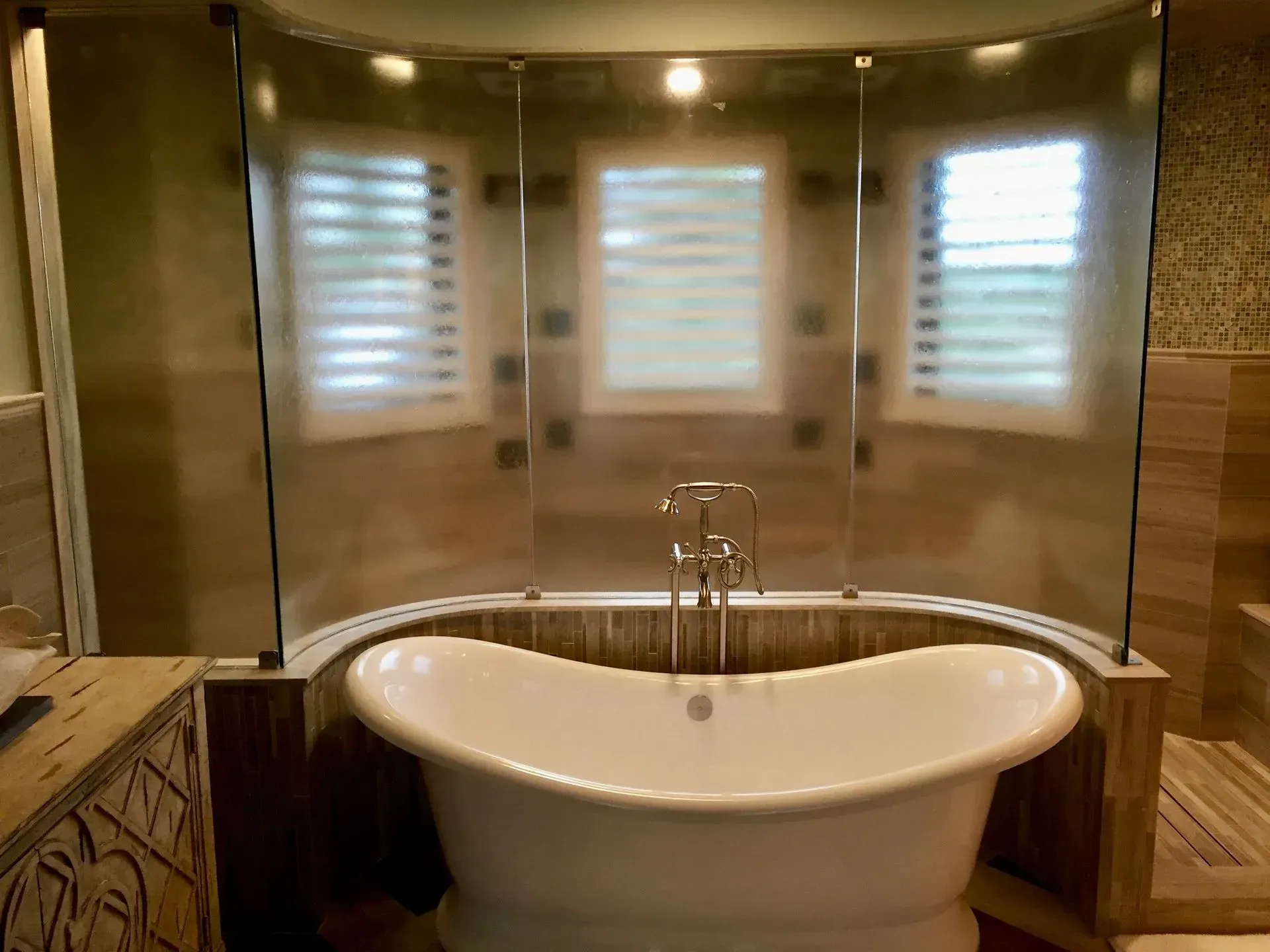 A bathroom with a bathtub and a cast glass wall