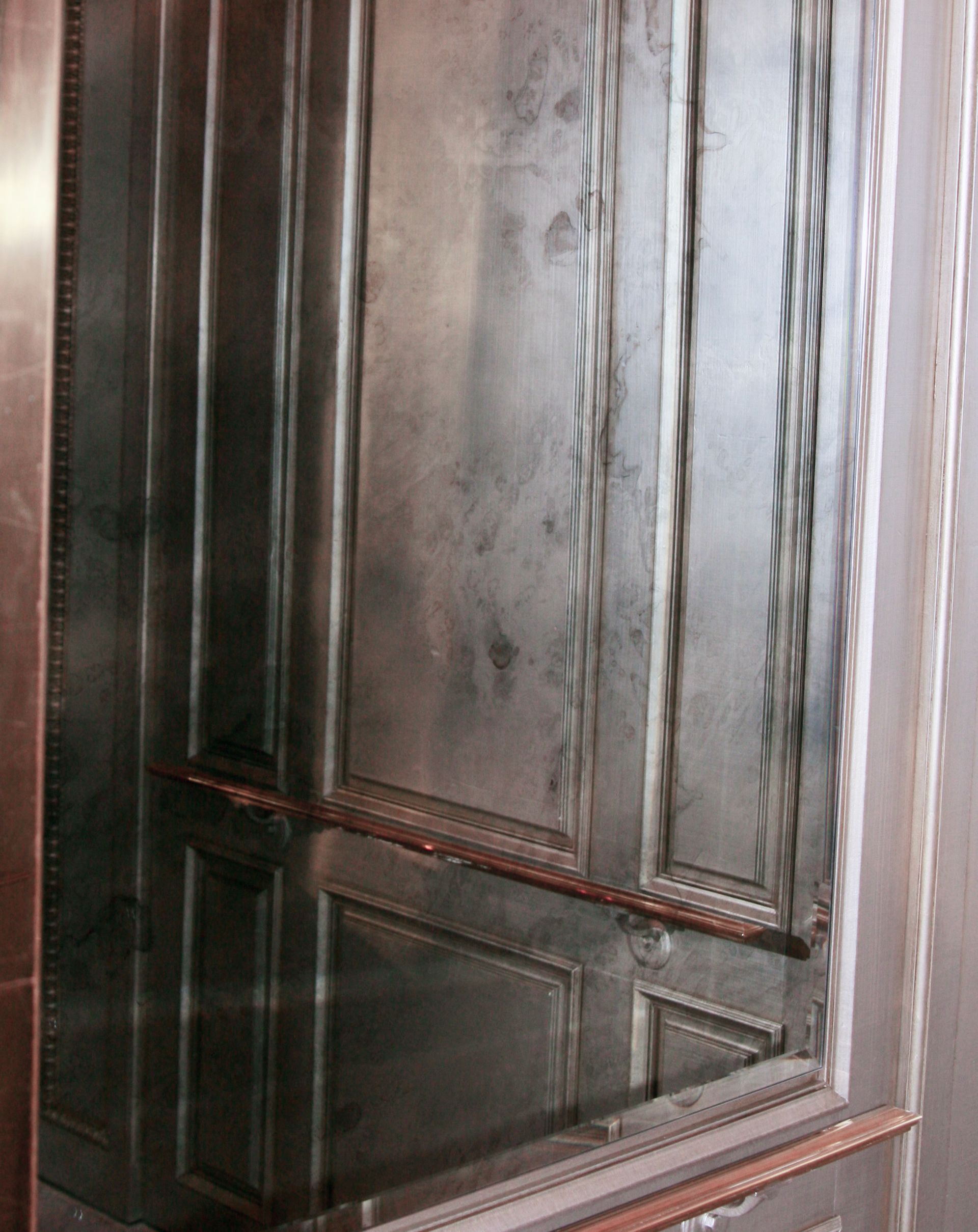 A rectangular mirror with a dark, antique-style frame featuring decorative rope-twist detailing on the side edges.