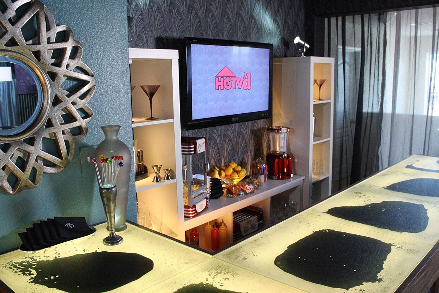 A living room with a bar made of liquid lava tiles and a flat screen tv