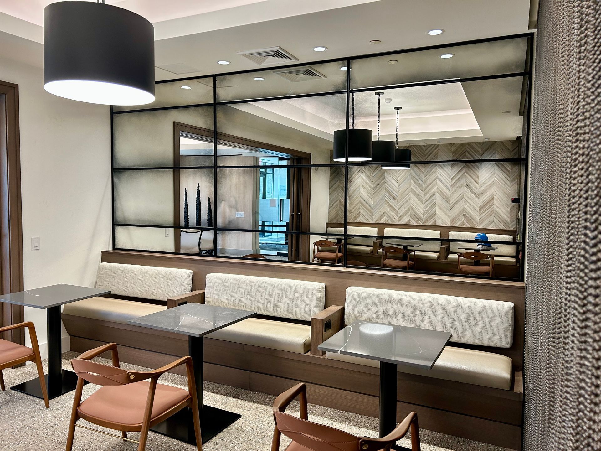 A dining room with tables and chairs and a couch.