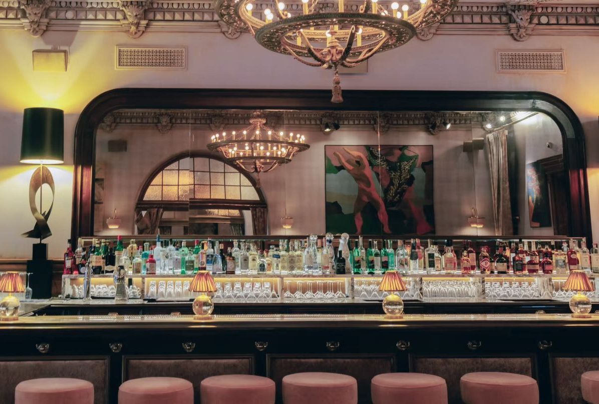 A bar filled with lots of bottles of liquor and stools.