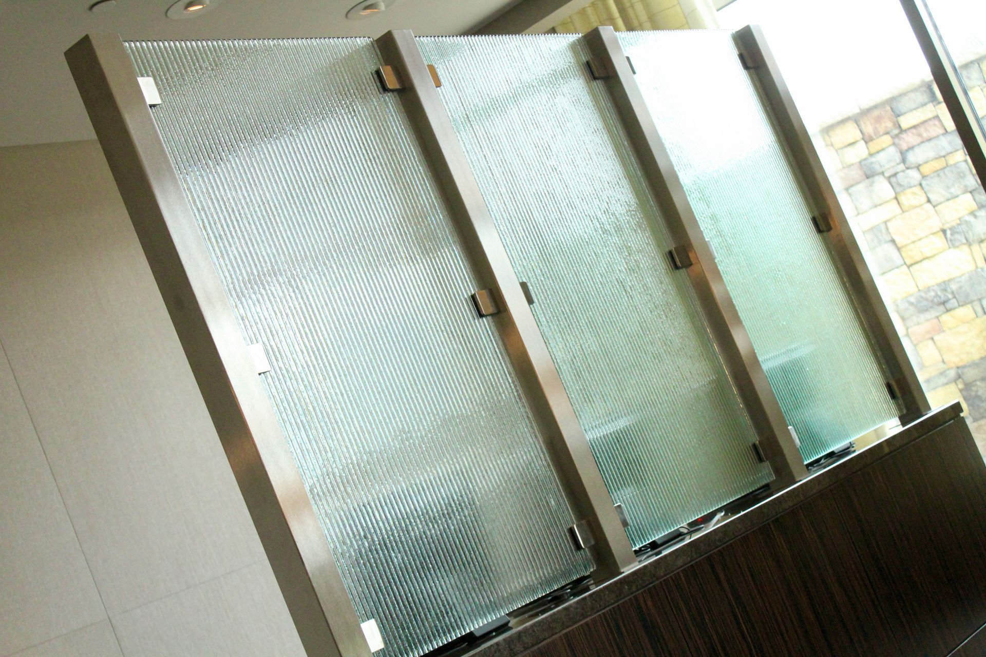 A decorative room divider with three vertical textured reeded glass panels.