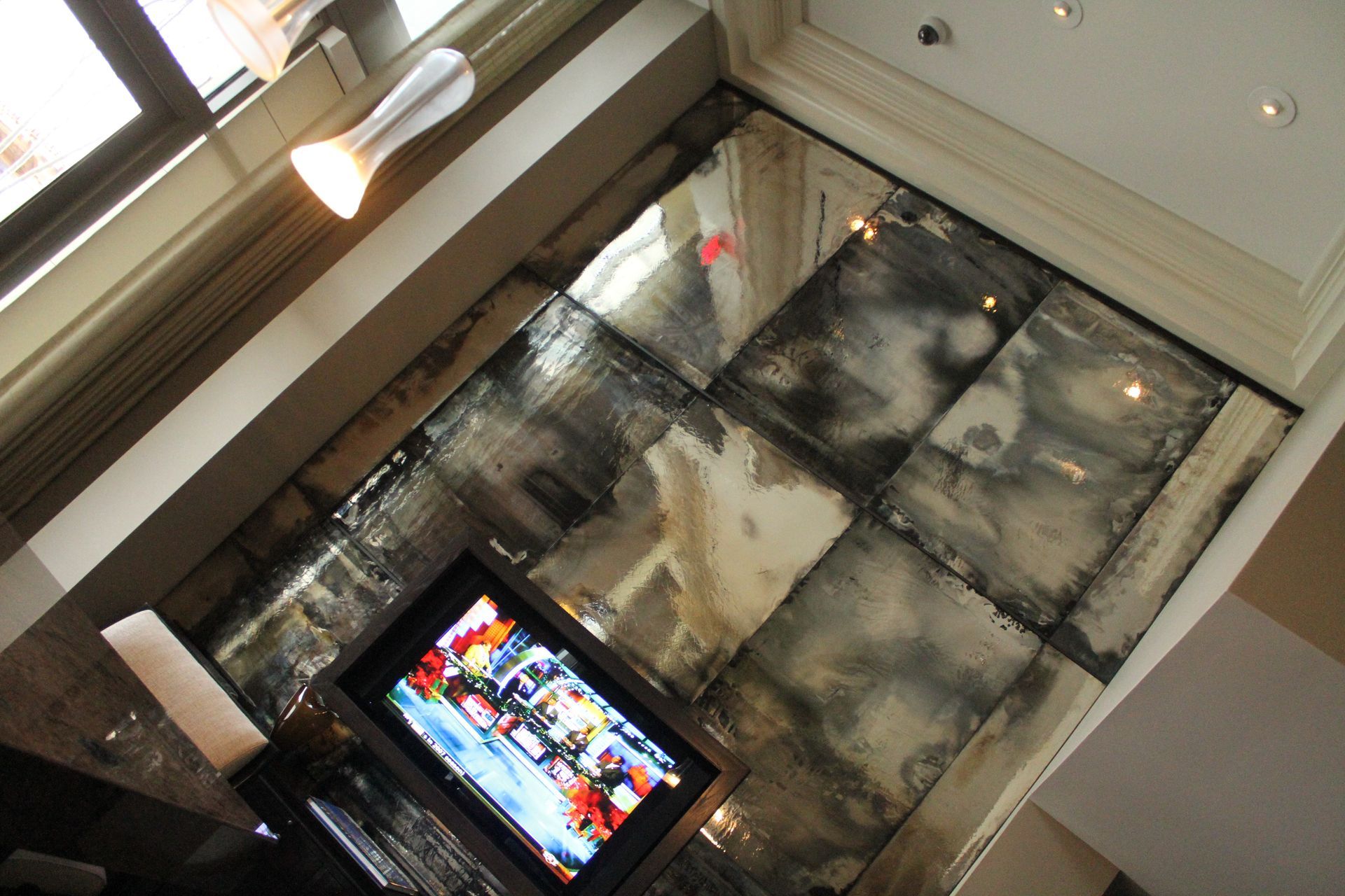 A flat screen tv is sitting in front of an antique mirrored wall