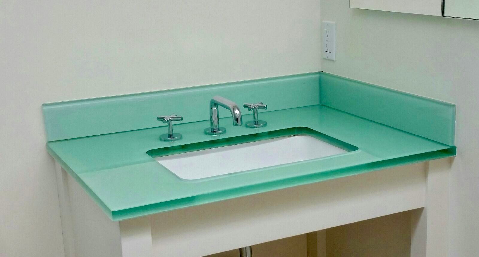Mint-green bathroom sink countertop with faucet and built-in basin