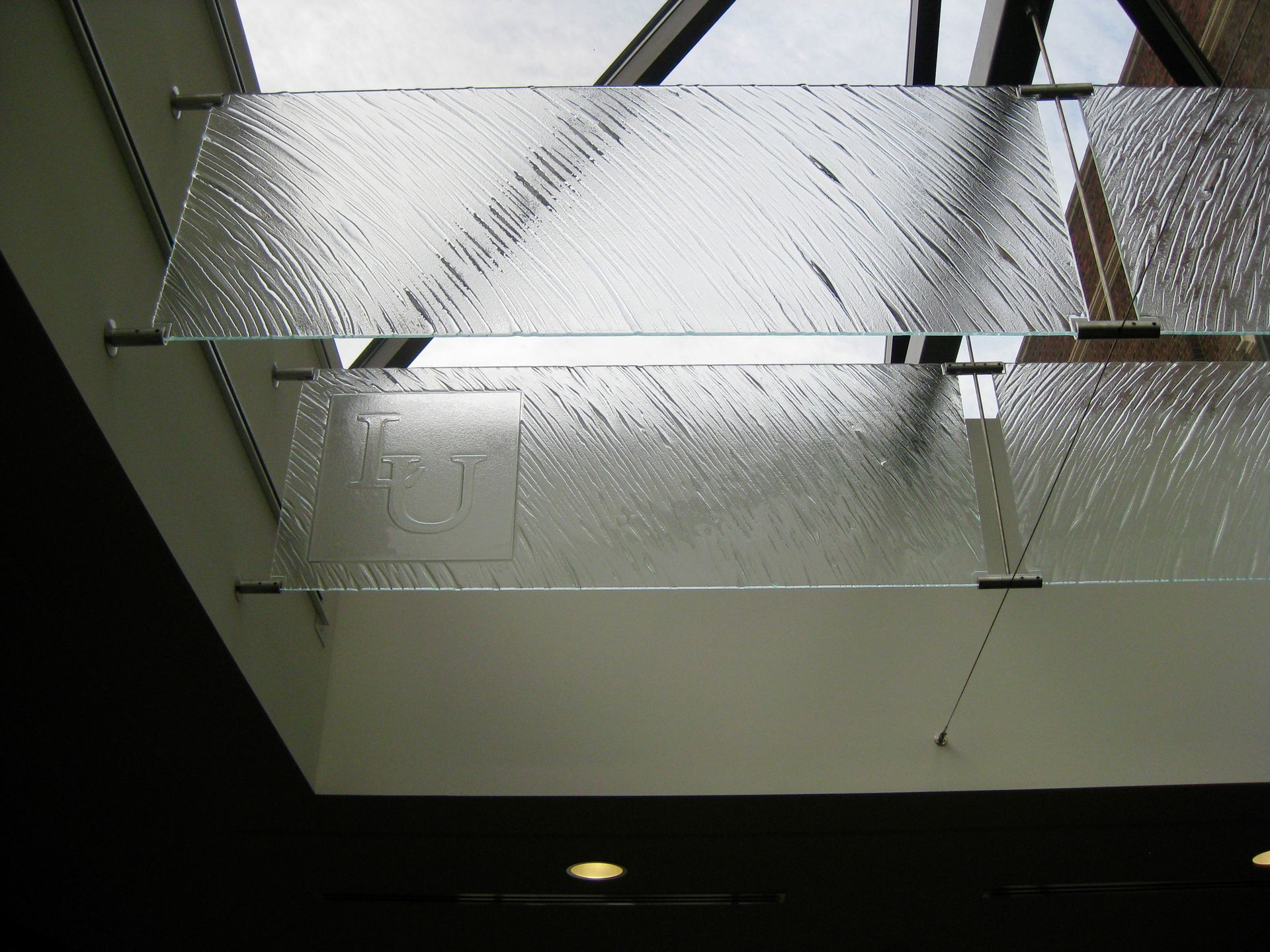 Textured glass panels are suspended from a ceiling frame, creating a decorative skylight feature.