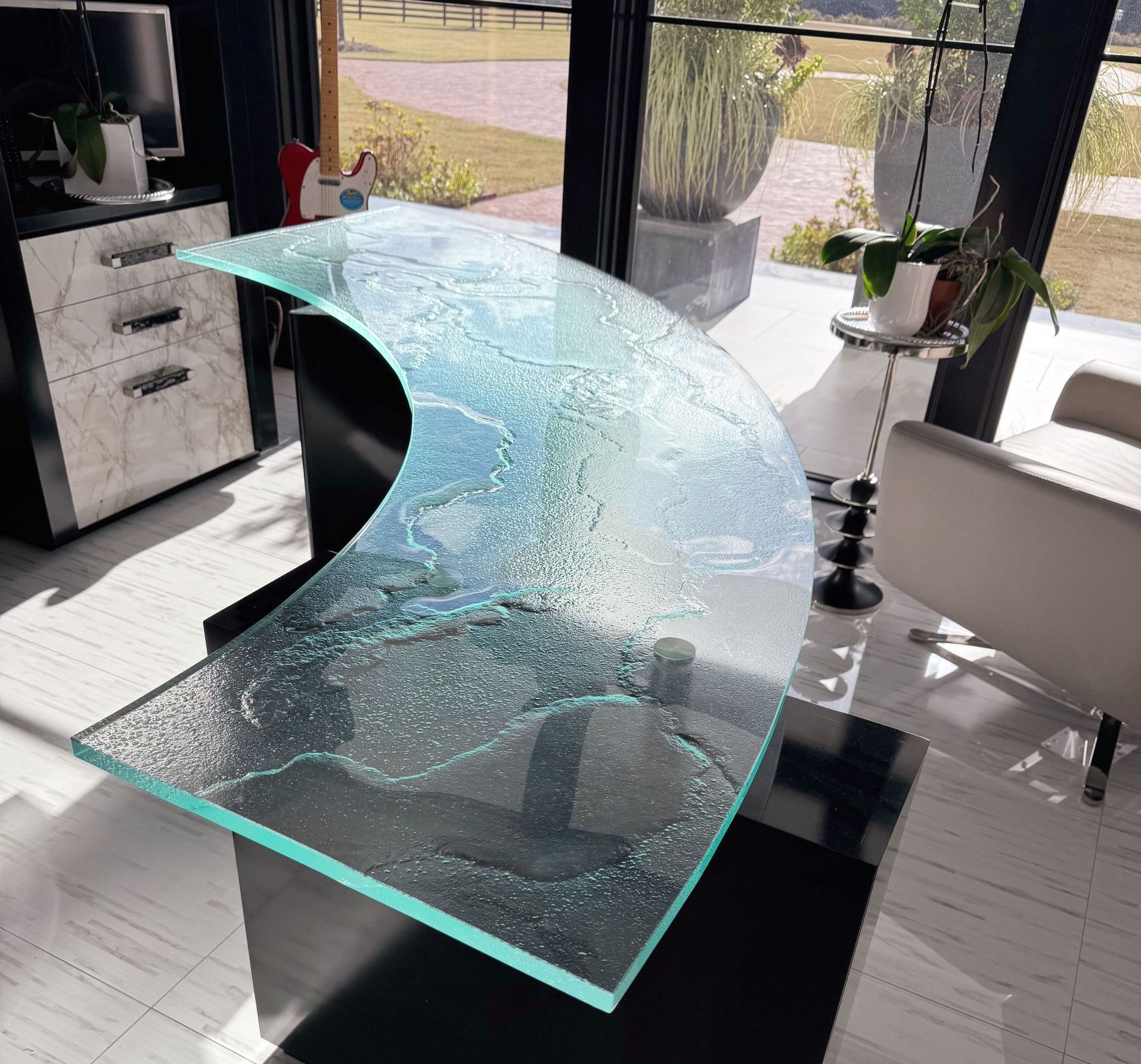 A glass table with a curved top in a living room