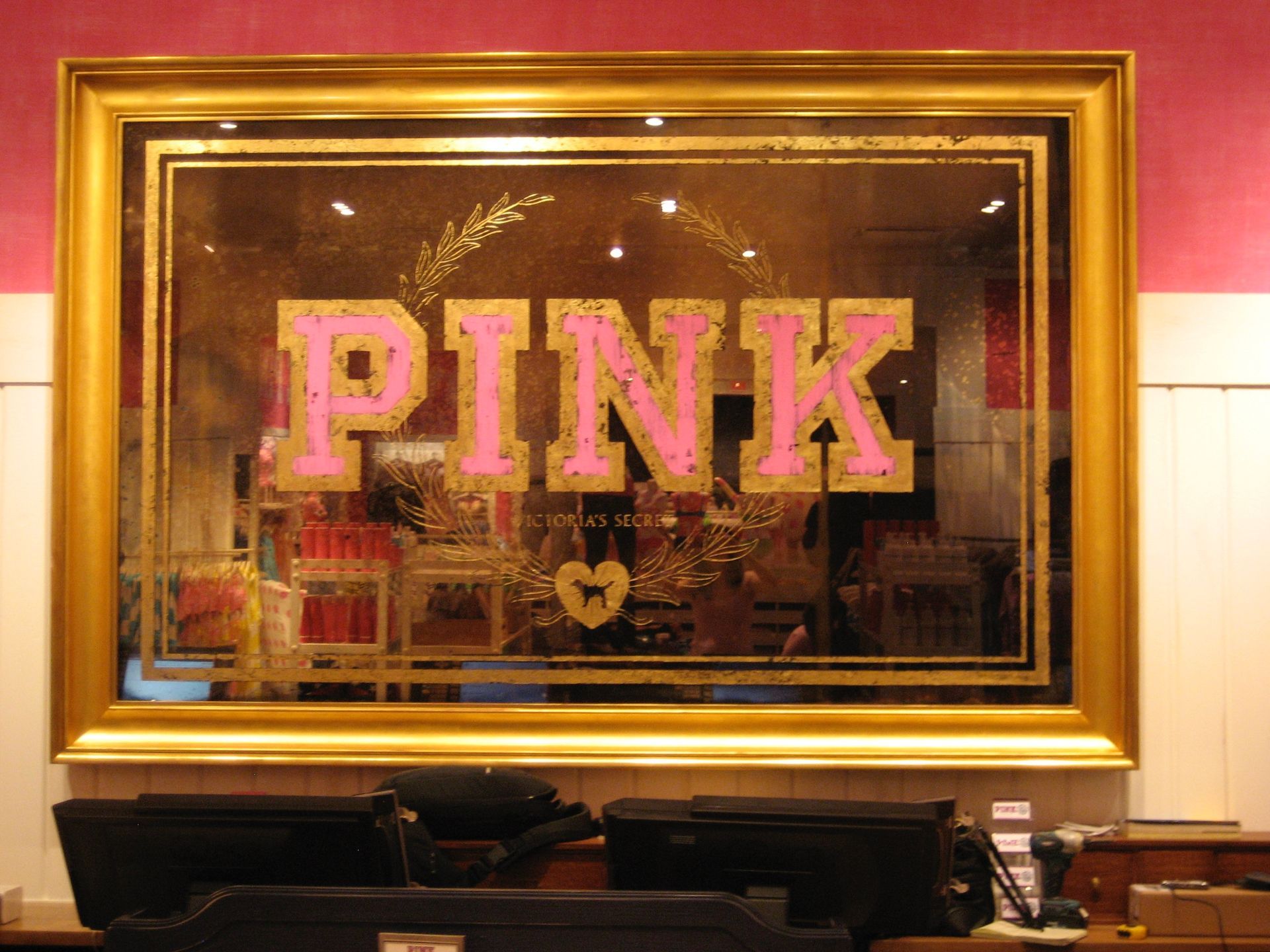 A antique glass framed mirror with the word pink on it