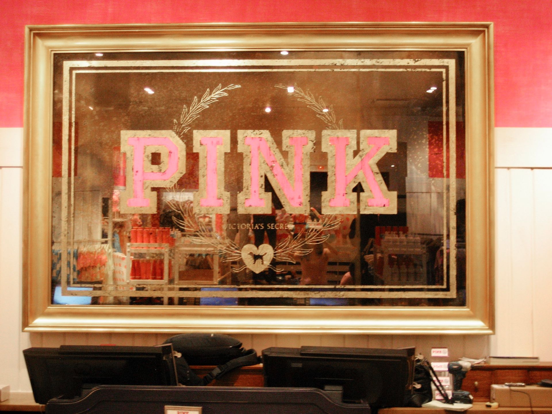 A framed antique mirror with the word pink on it