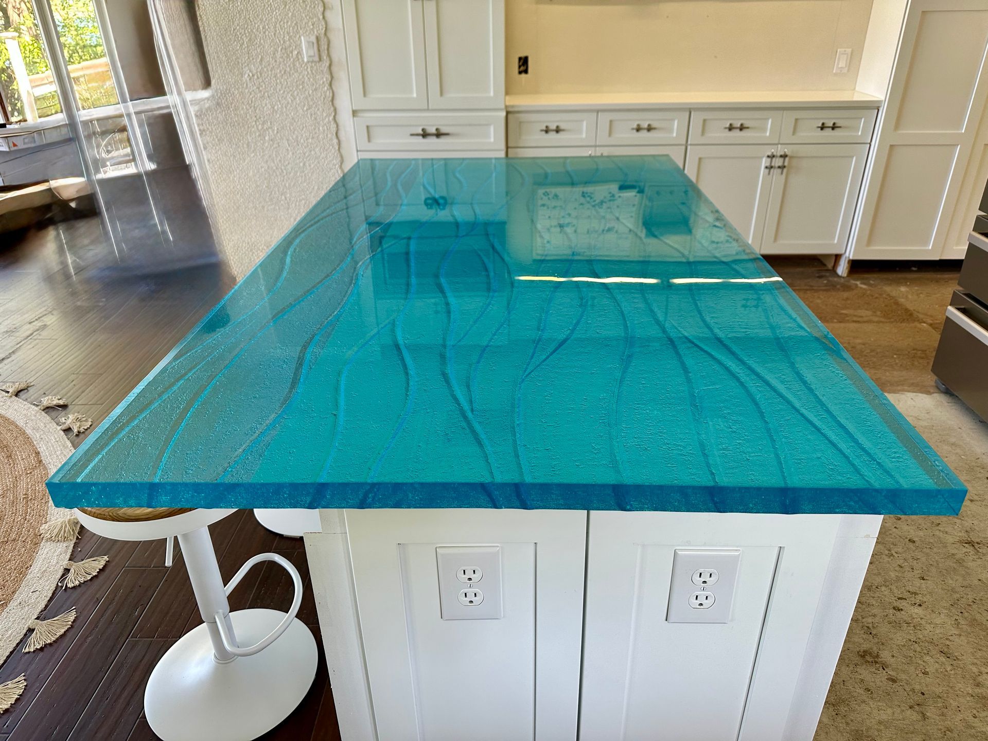 A kitchen island with a blue counter top and white cabinets