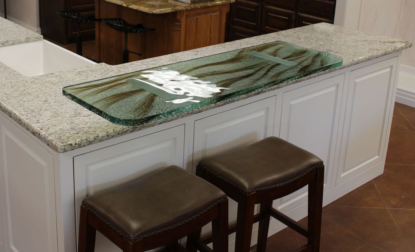 A kitchen with a glass counter top and two stools