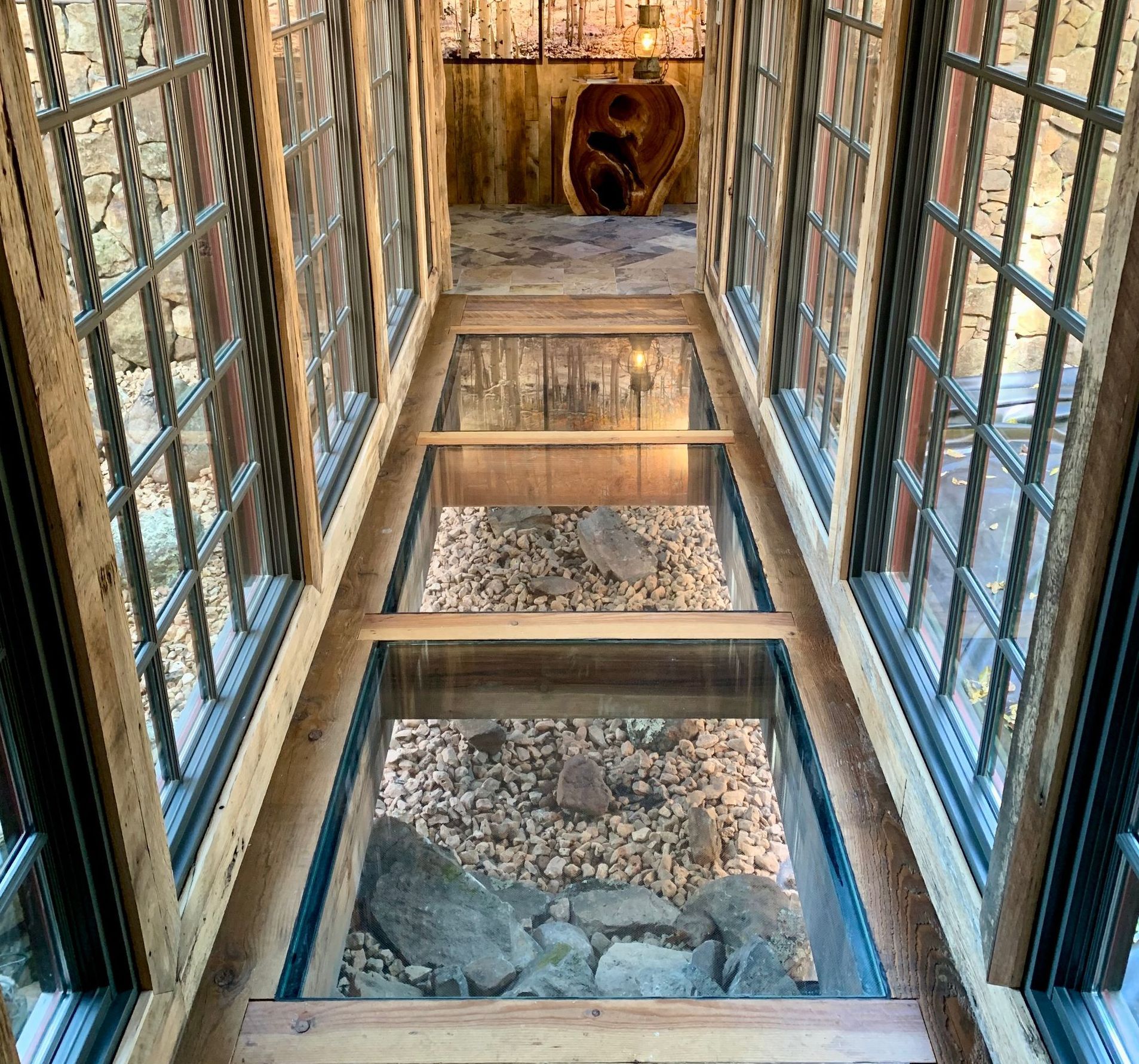 A long hallway with lots of windows and a glass floor.