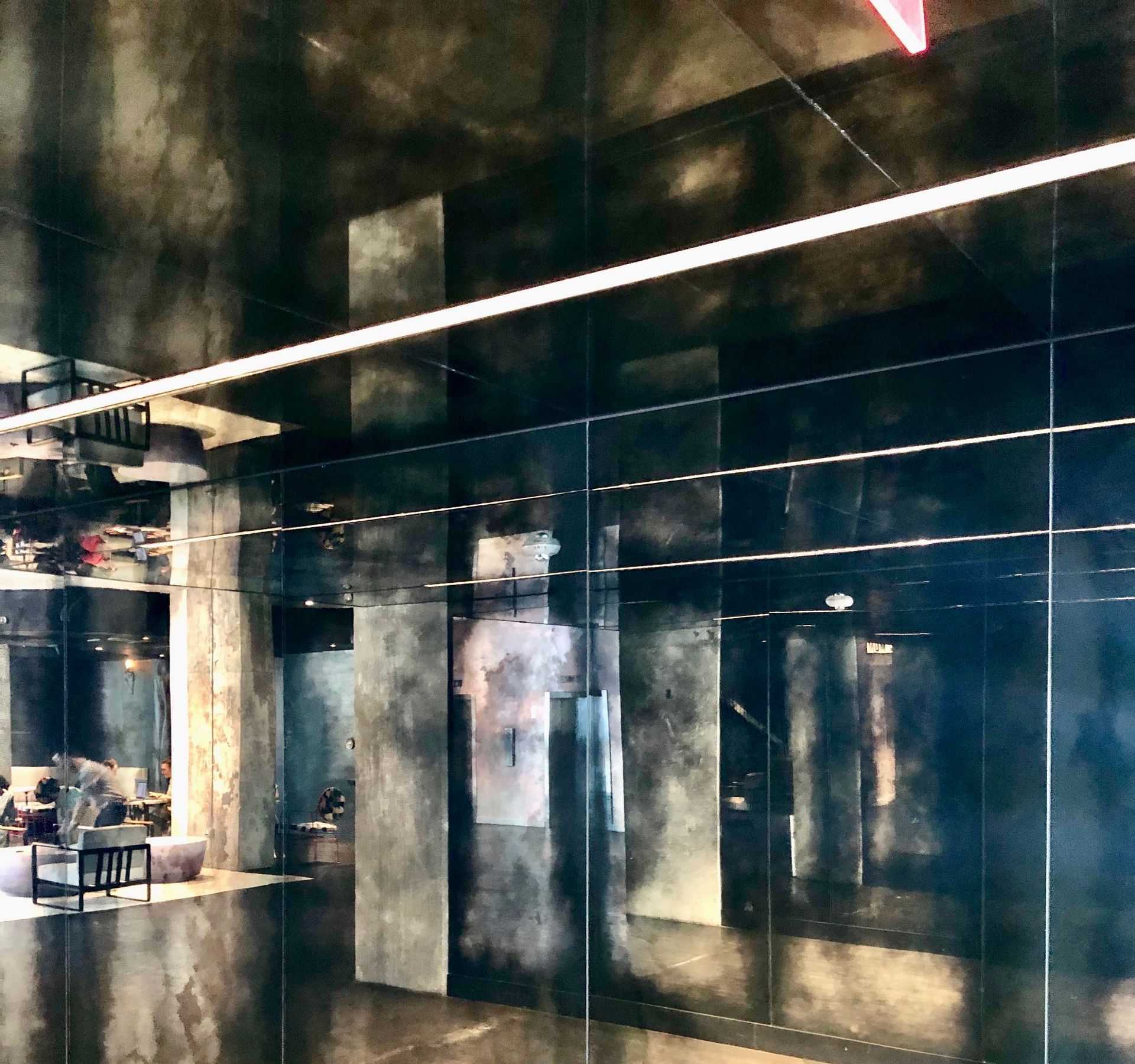 A room with a lot of antique mirrors and a light hanging from the ceiling