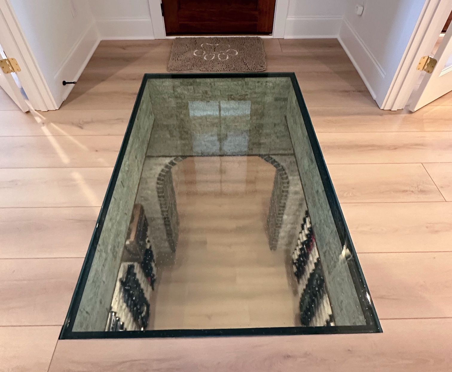 A glass floor in a hallway leading to a wine cellar.