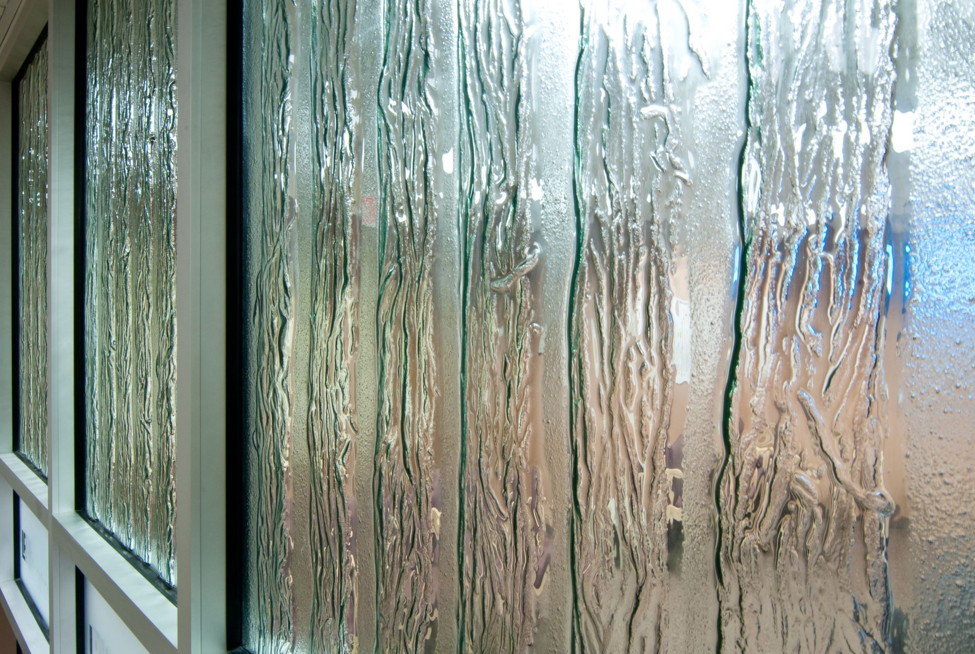 Close-up of a panel of cast glass with an integrated pattern like tree bark.