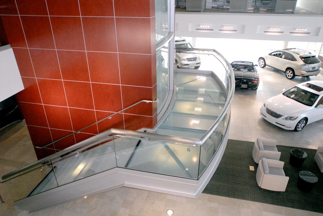 An aerial view of a car showroom with cars on display with glass stairs