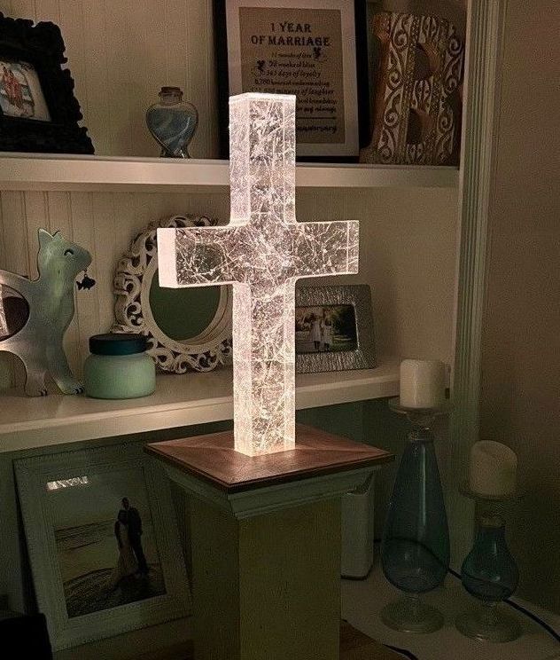 A custom glass memorial in the shape of a cross made from clear glass with veining throughout.