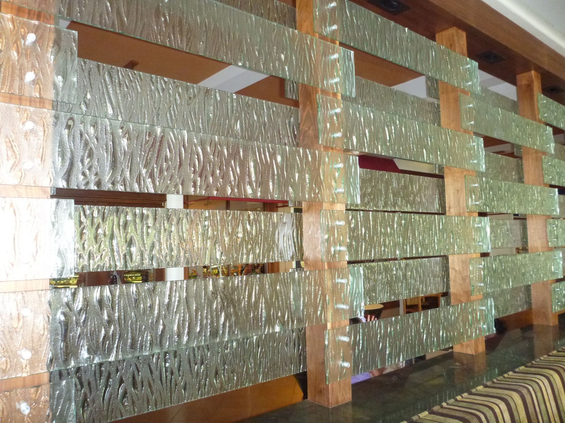 A room with a divider made of cast glass and wood