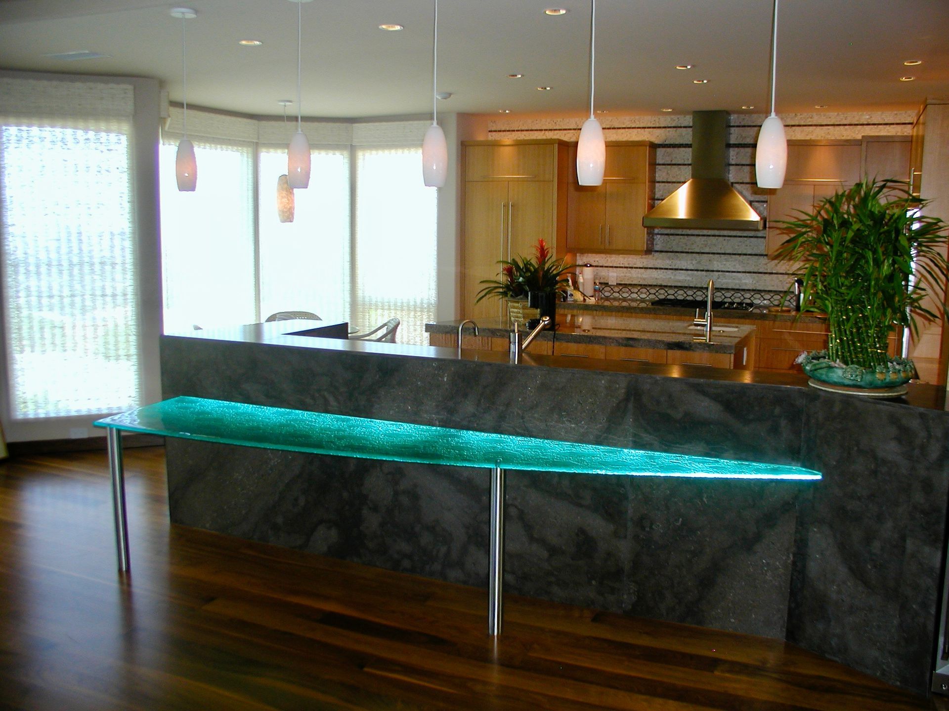 A kitchen with a glass table in the middle