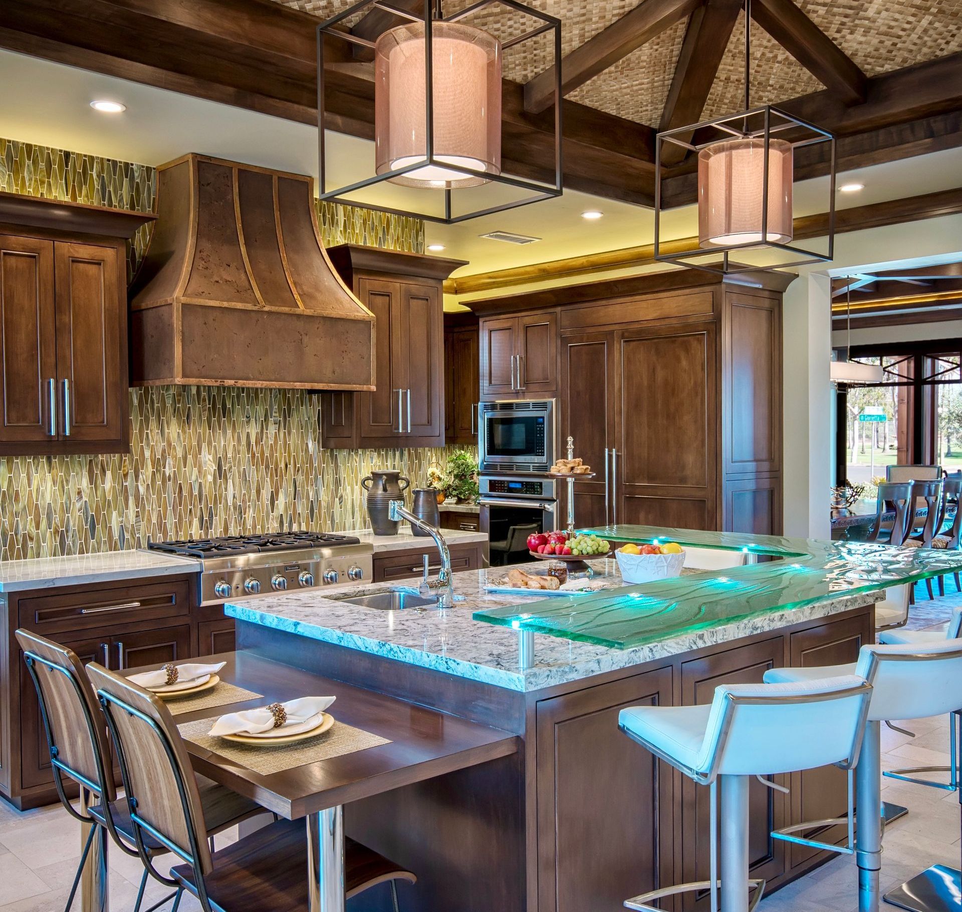 A kitchen with a large glass counter top and tables and chairs