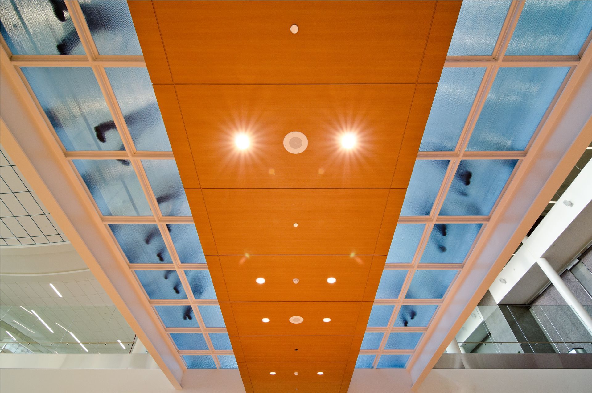 Glass flooring with people walking on it, seen from below.