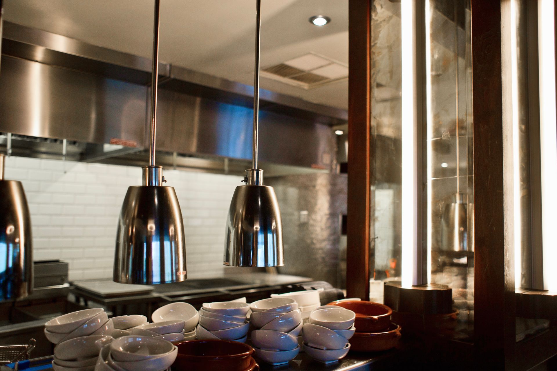 A kitchen with a lot of bowls and plates on the counter.