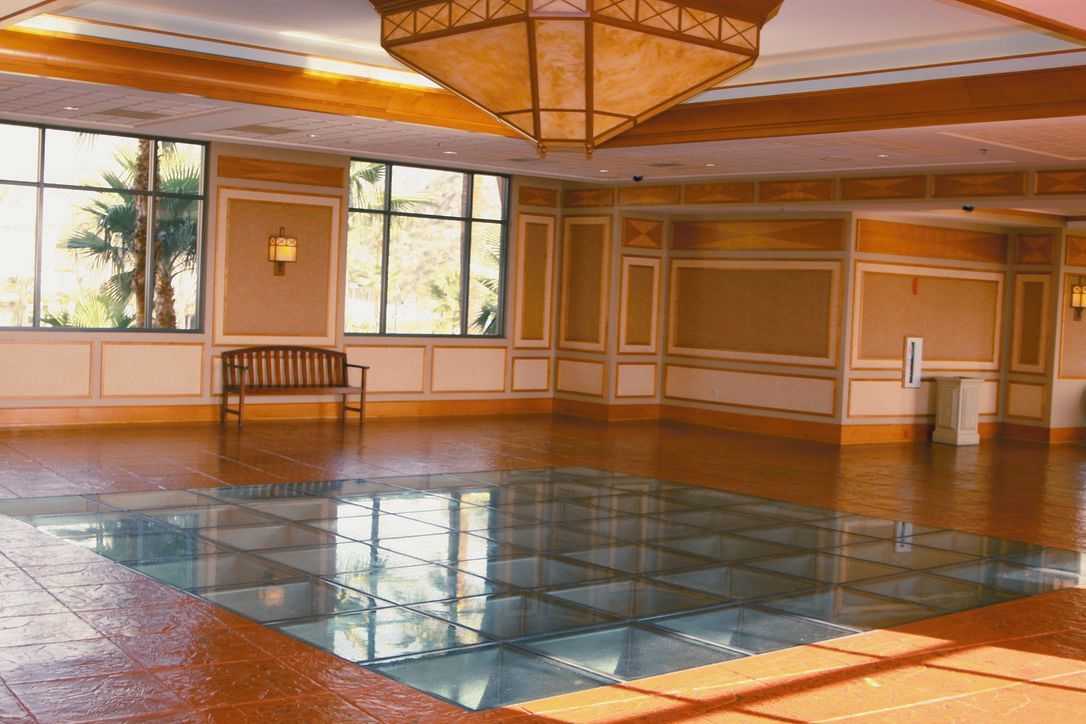 Bright room with glass floor sections; brown and cream walls; windows; bench.