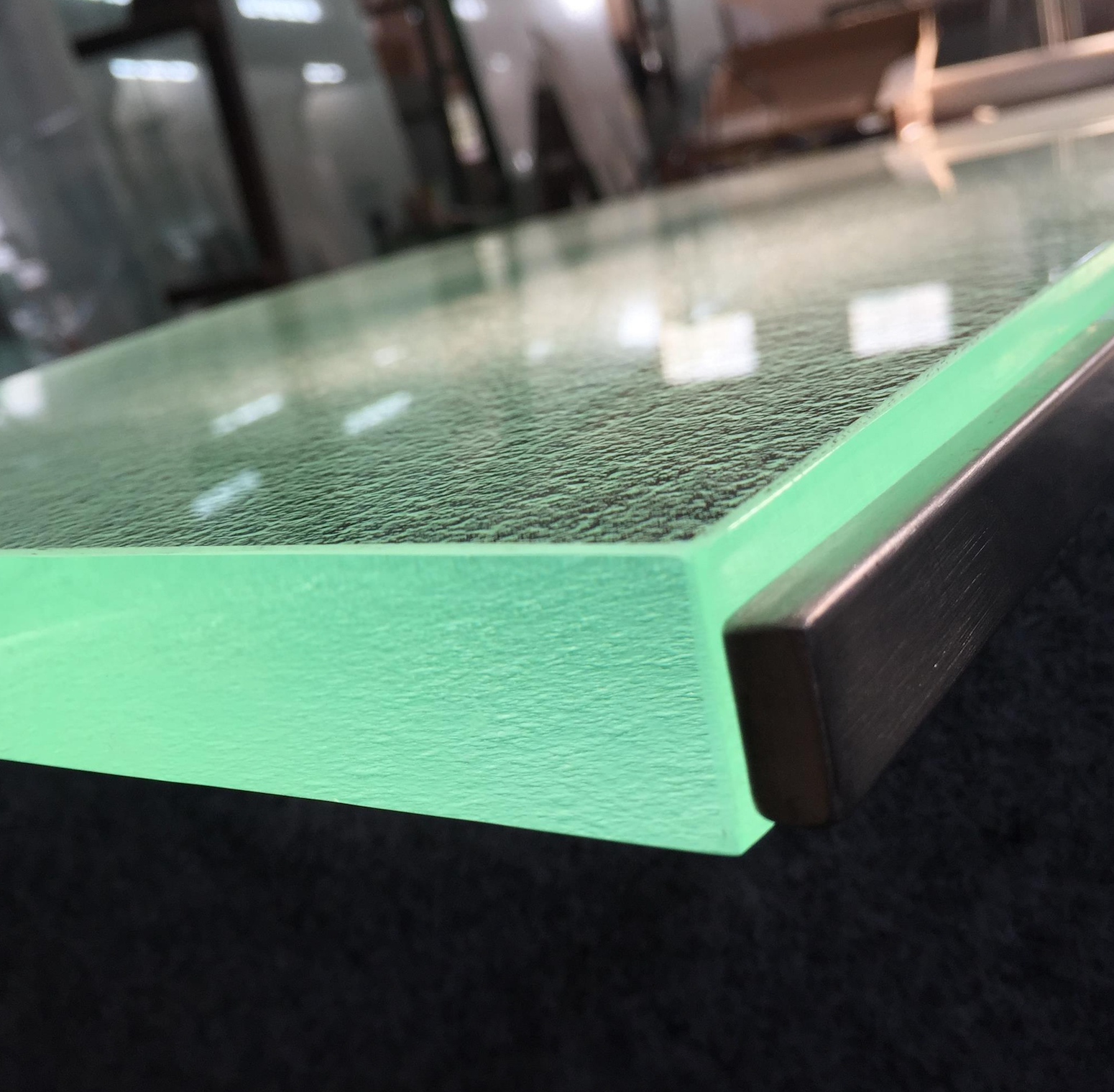 A glass counter top with a green molding  is sitting on a table.